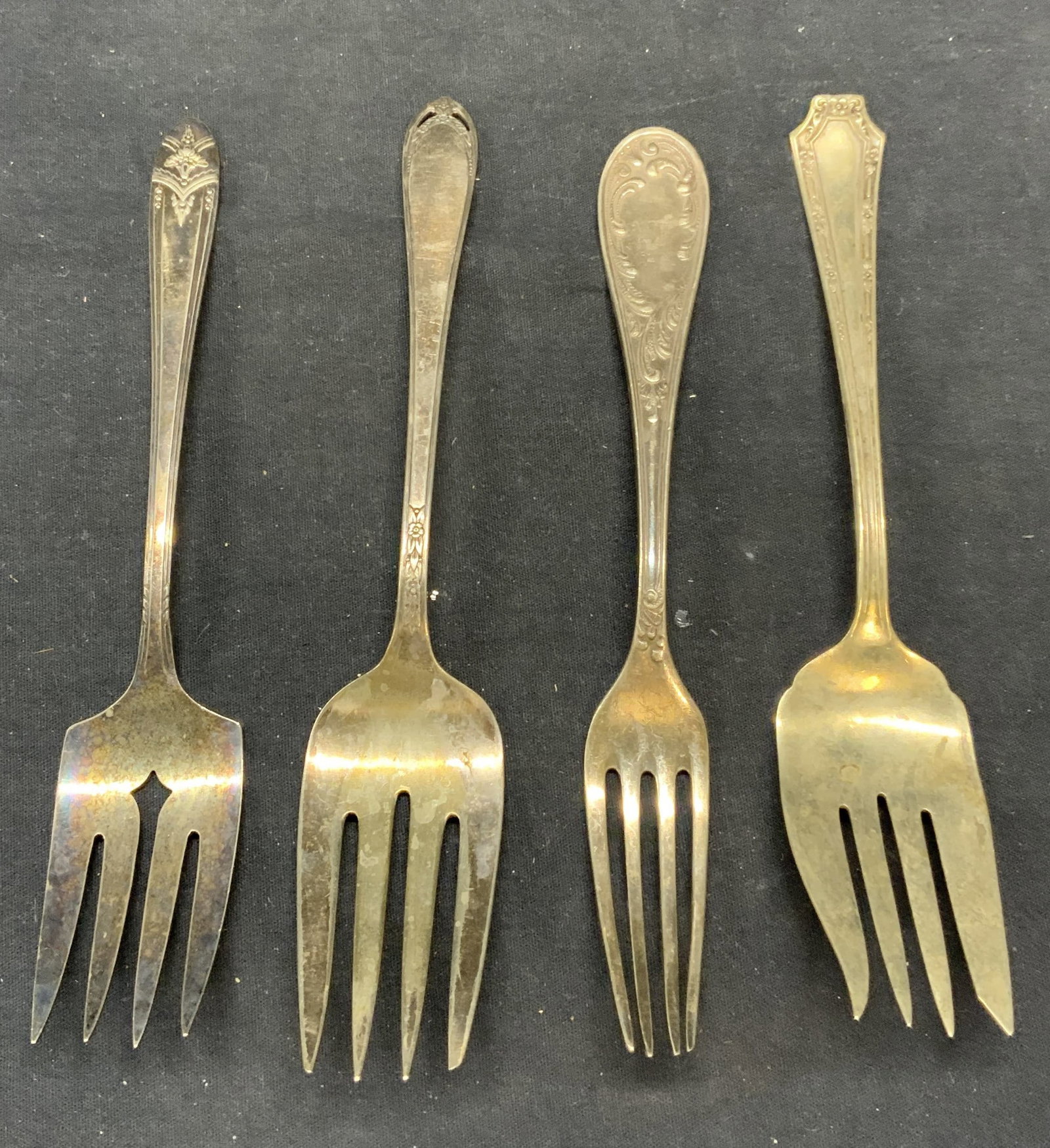 Lot 4 Vintage Rogers & More Silver Plate Forks: Lot of 4 vintage silver plated forks. 2 pieces marked Rogers, 1 marked Fairfield, 1 marked illegibly. All pieces have surface wear consistent with exposure. Largest piece measures approx. 8.5 inches l