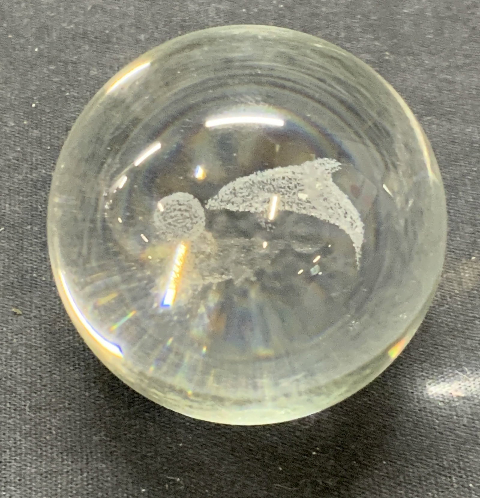 Art Glass Dolphin Sphere Paperweight: Art glass sphere paperweight with controlled bubble dolphin motif. Some surface wear consistent with exposure. Measures approx. 1.75 inches diameter. Art glass, art glass paperweight, dolphin paperwei
