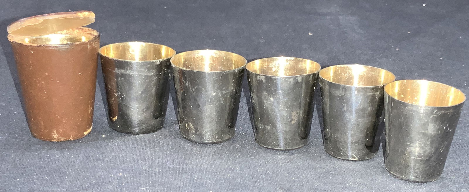 Vintage Leather Lined Portable Shot Glasses: Vintage leather lined portable shot glasses. Comes in leather case marked Germany. Set of 6 steel shot glasses each a smaller size than the other. Largest glass is approximately 1.75 inches tall and t