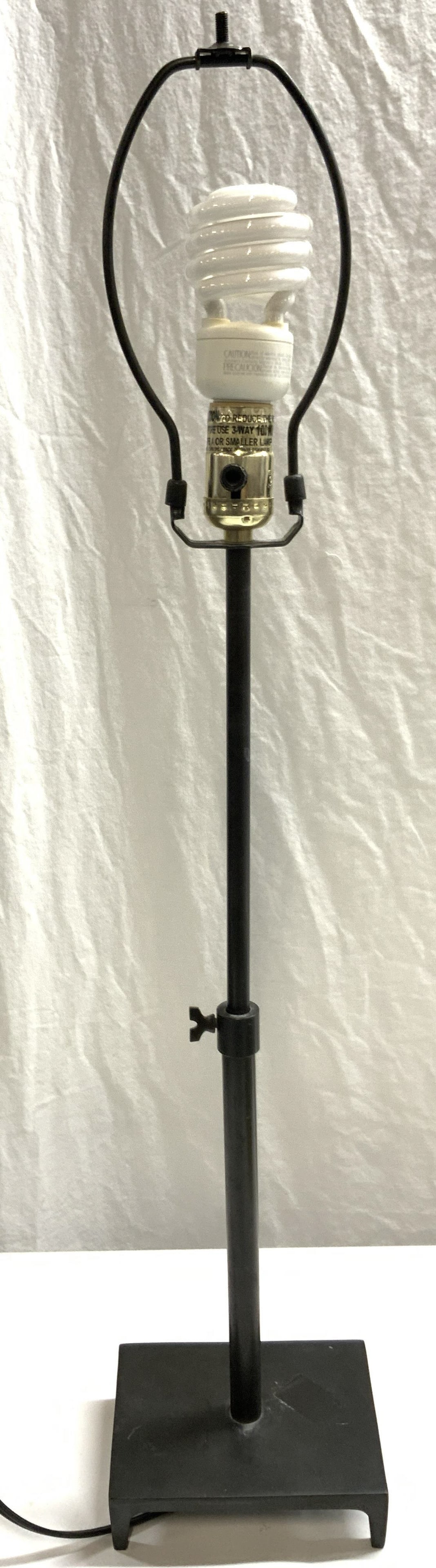 Black Metal Adjustable Length Table Lamp: Black metal table lamp with adjustable length. Measures approx. 6.25 x 4.75 x 31 inches including harp at fully extended length. Not tested for function. Some surface wear consistent with exposure. La