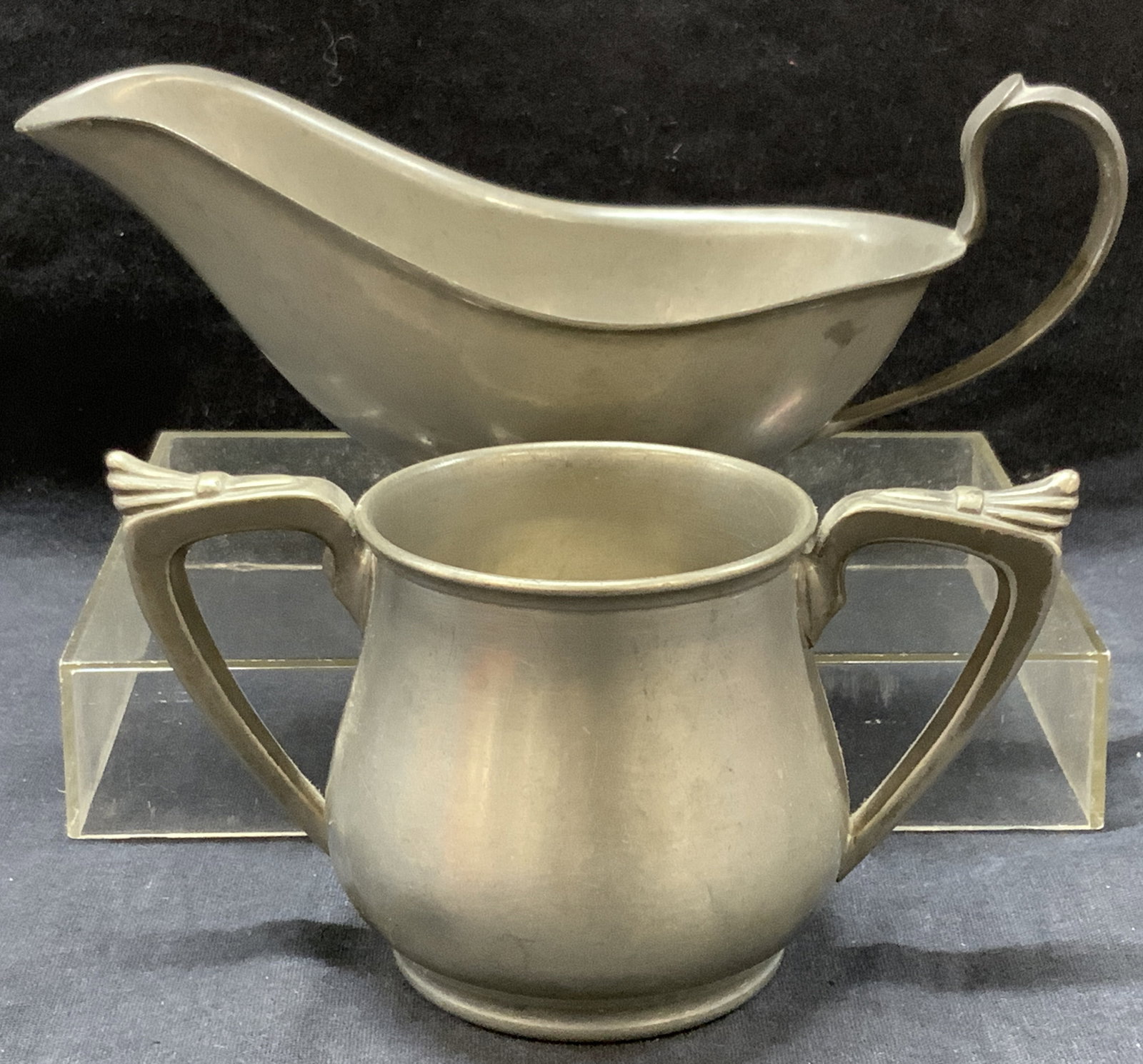 2 Ray Silver Co & Crescent Pewter Accessories: Lot of 2 pewter accessories. 1 double handled pewter vessel marked Ray Silver co. 3 inches tall, And 1 pewter gray boat marked Crescent Pewter. Approximately 3.75 x 7,5 inches Moderate wearing due to