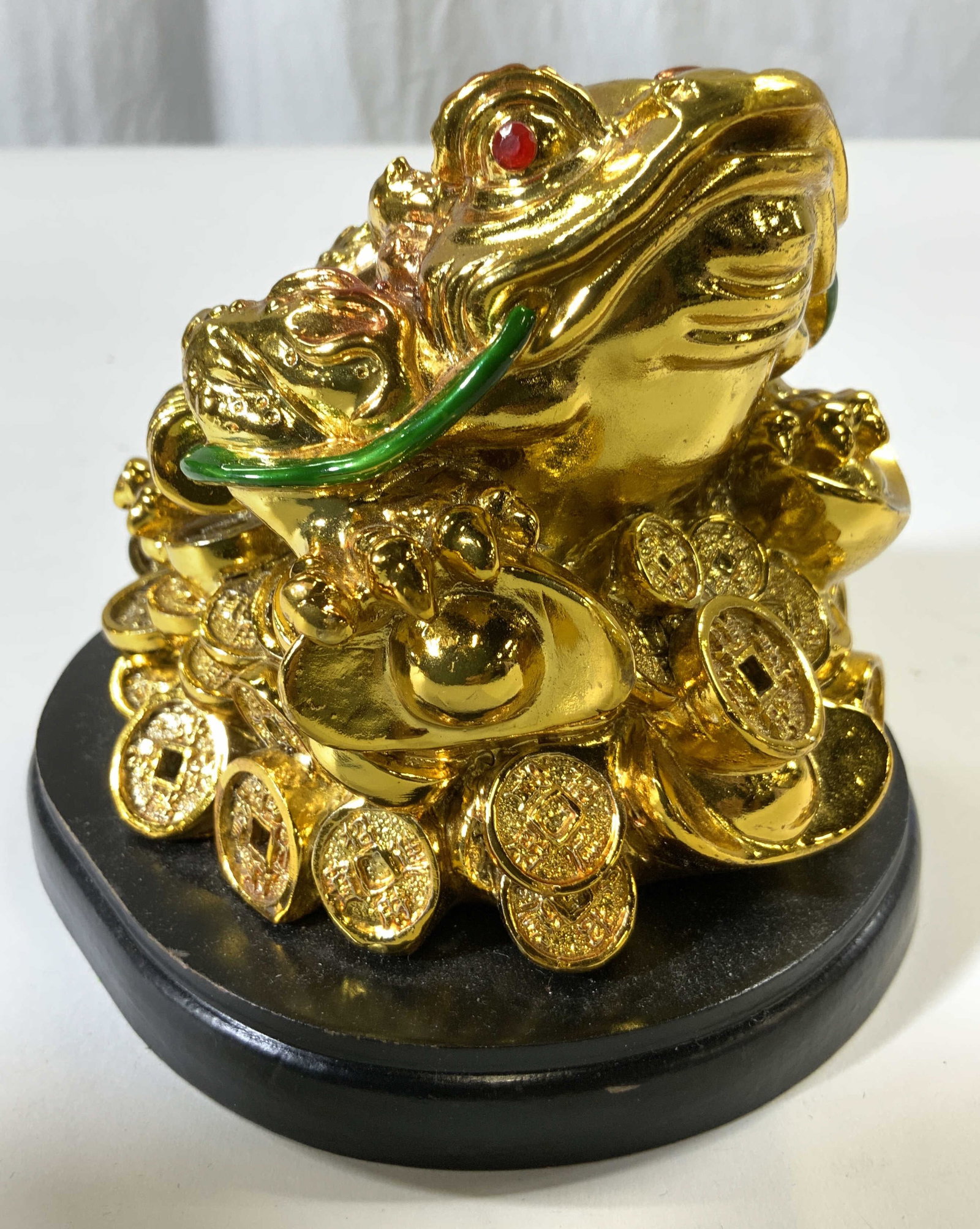 Gilt 3 Legged Feng Shui Money Frog: Piece appears to be Gilt enamel. Statue depicts three legged Feng Shui Money Frog statue on black base which appears to be wooden, possibly veneer. Piece measures approx 4.5 inches tall & wide 5.25 in