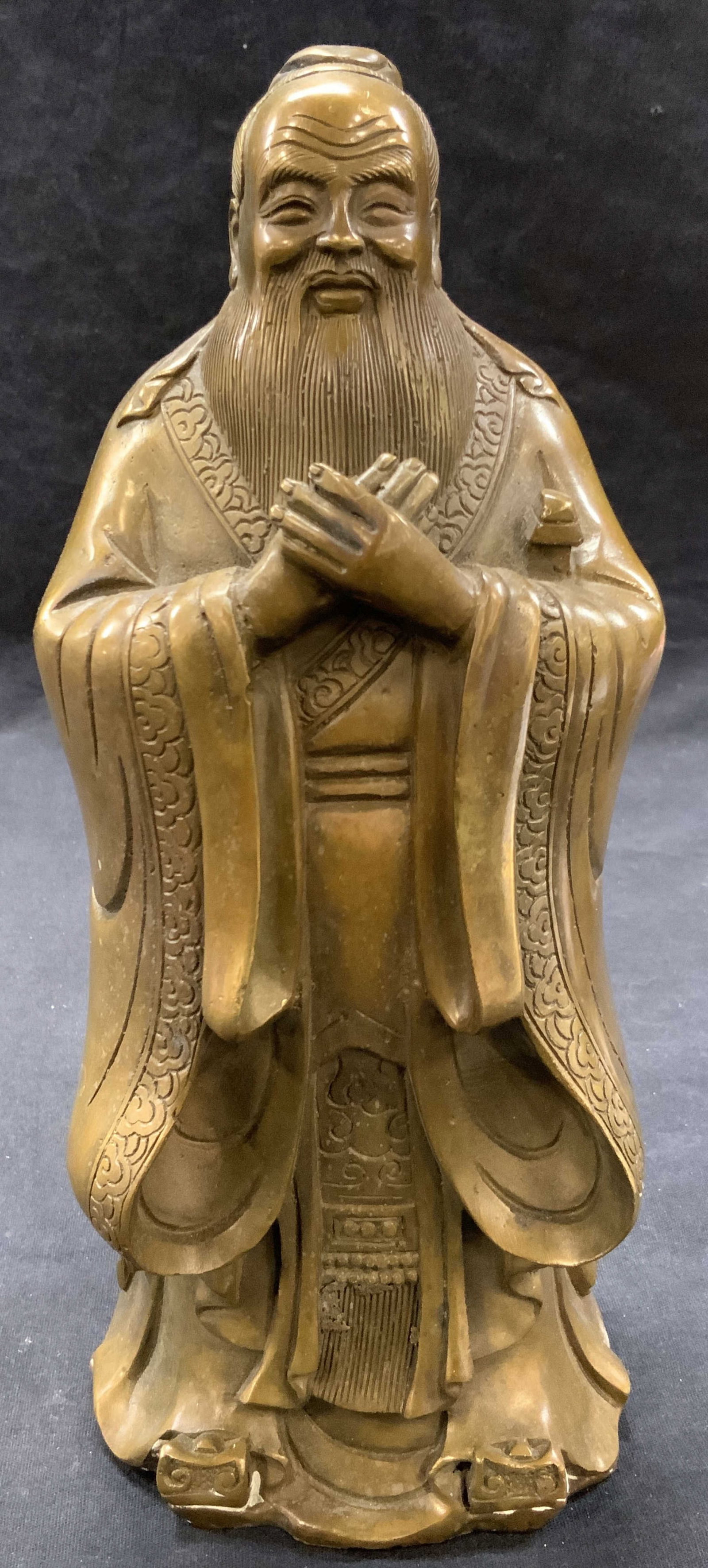 Cast Brass Confucius Figure Sculpture: Cast brass, sculpture of Confucius with hand clasped in font of him Approximately 10.5 inches tall. Moderate wearing to sculpture and evident oxidation throughout. Cast metalworks, cast brass, Confuci