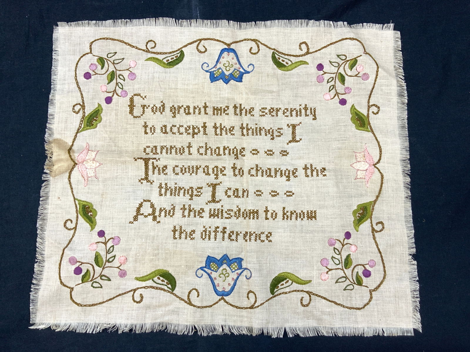 Vintage Cross Stitch Serenity Prayer Panel: Vintage cross stitch panel reading the Serenity Prayer with embroidered flowers and berries on border. Approximately 16 x 18 inches. Evident wearing and blemishes to linen. Vintage cross stitch linens