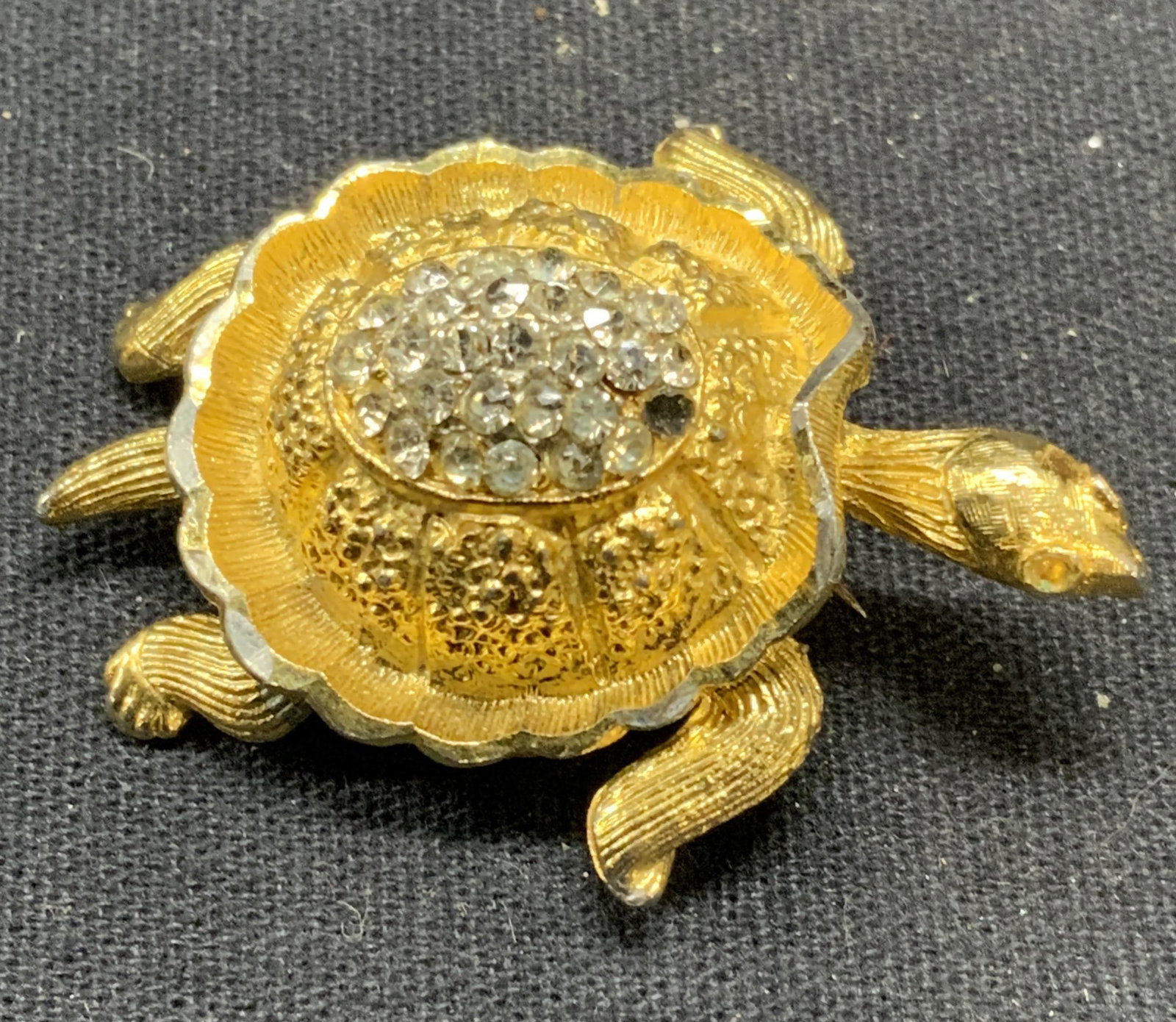 Vintage BSK Gold Tn Crystal Turtle Brooch: Vintage BSK gold tone crysta, decorated turtle brooch. Signed to underside. Hinge pin to underside. Some surface wear including scratching and loss to crystal observed. Measures approx. 1 5/8 x 1.25 i