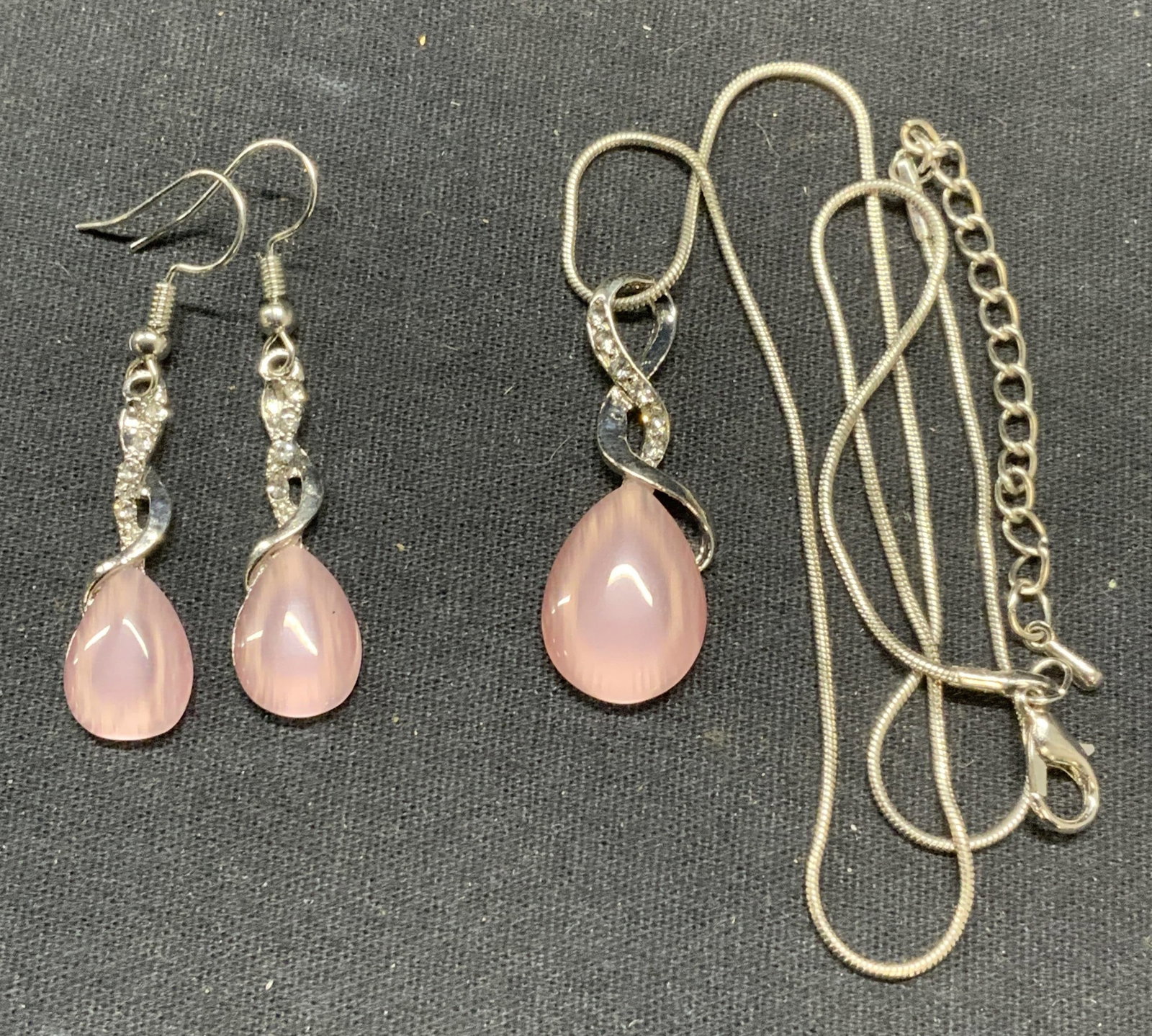 Silver Tn Crystal Pendant Earring & Necklace Set: Matching necklace and earring set. Silver tone with colorless crystal and iridescent pink toned Cabochon pendants. Earring shave hook backings, measure approx. 1.25 x 3/8 inches. Necklace drop length 