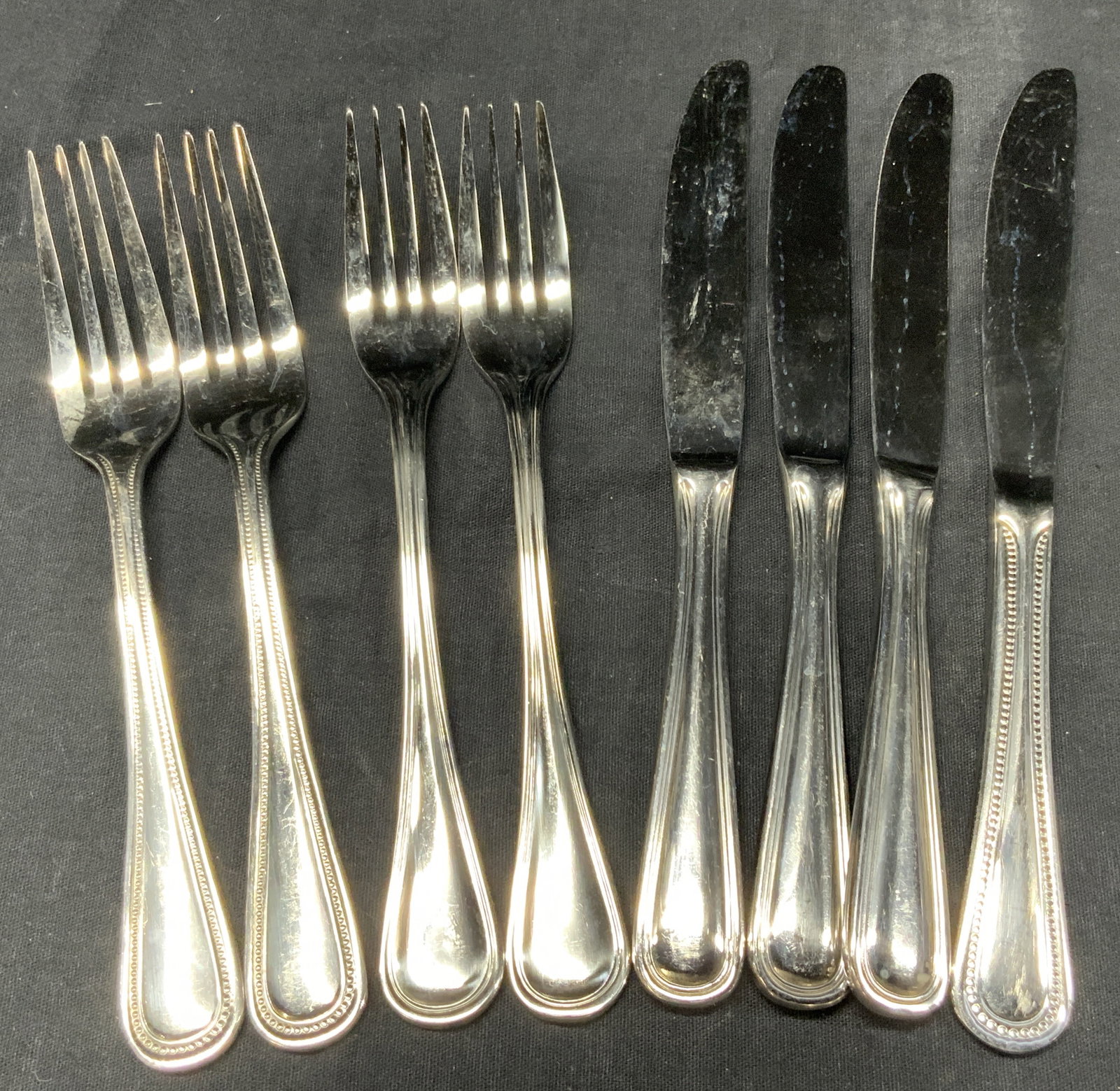 8 Wallace Steel Utensils: Set of 8 Wallace steel utensils,18/10 2 dinner forks, and 2 salad forks, approx 7.5 inches long and 4 knives, approximately 9 inches long. Some have ribbed patterns on their handles, others do not. Al