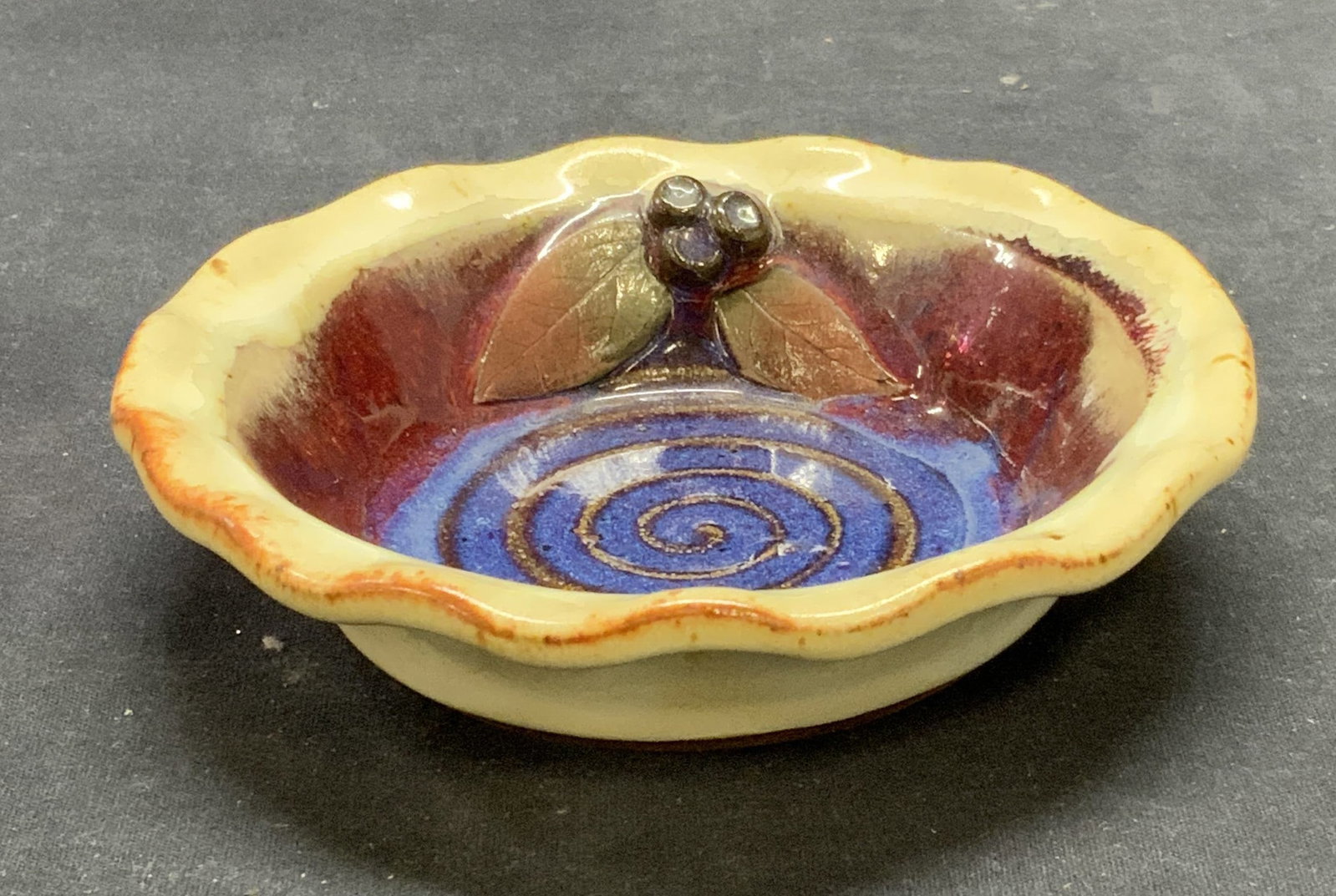 Signed Art Potter Berry Bowl: Signed art pottery bowl with berry motif. Signed to underside, illegible. Measures approx. 5.75 x 1.25 inches. Some surface wear consistent with exposure. Art pottery, art pottery bowl, berry bowl, co