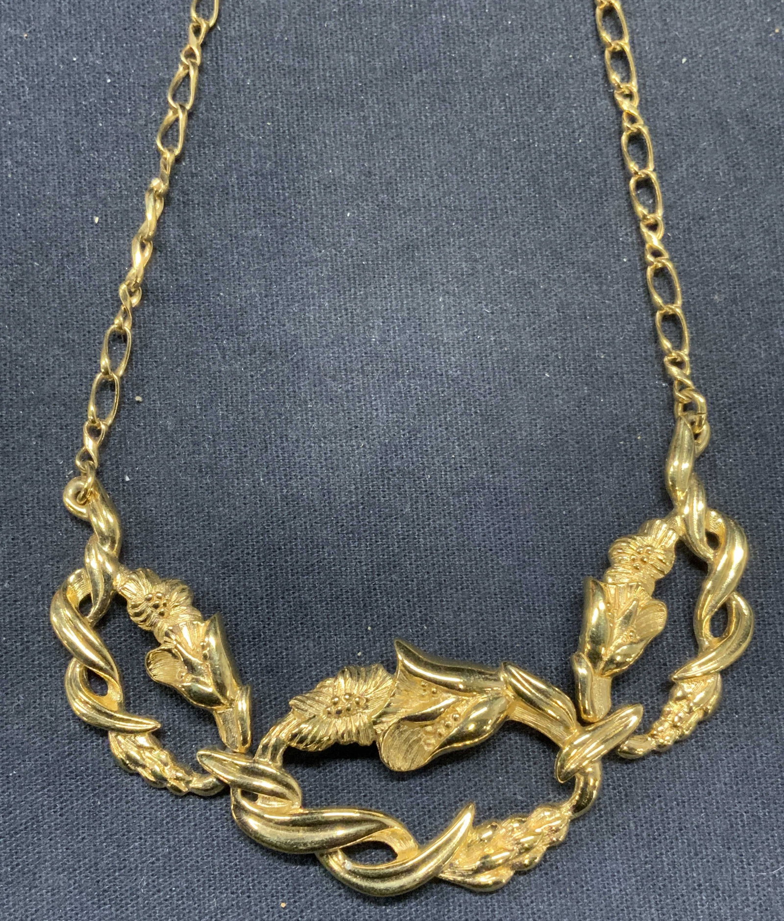 MONET Gold Tone Floral Pendant Necklace: Monet gold tone necklace with floral pendant. Signed to underside on pendant. Some surface wear including scratched observed. Measures approx. 16 inches total length. Drop length approx. 7 inches. Pen