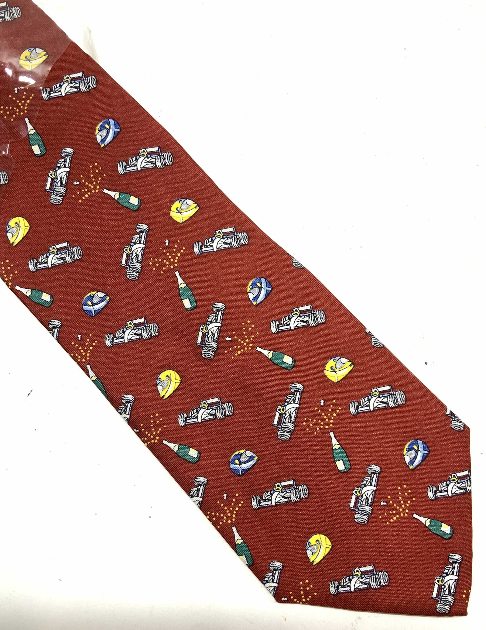 Burgundy Race Car Celebration Silk Tie, Italy NiP: New in package , never worn imported luxury BMW Silk Tie, made in Italy. This is a part of a luxury BMW tie collection. Burgundy color with graphic print of race car helmet, race car, and popping cham