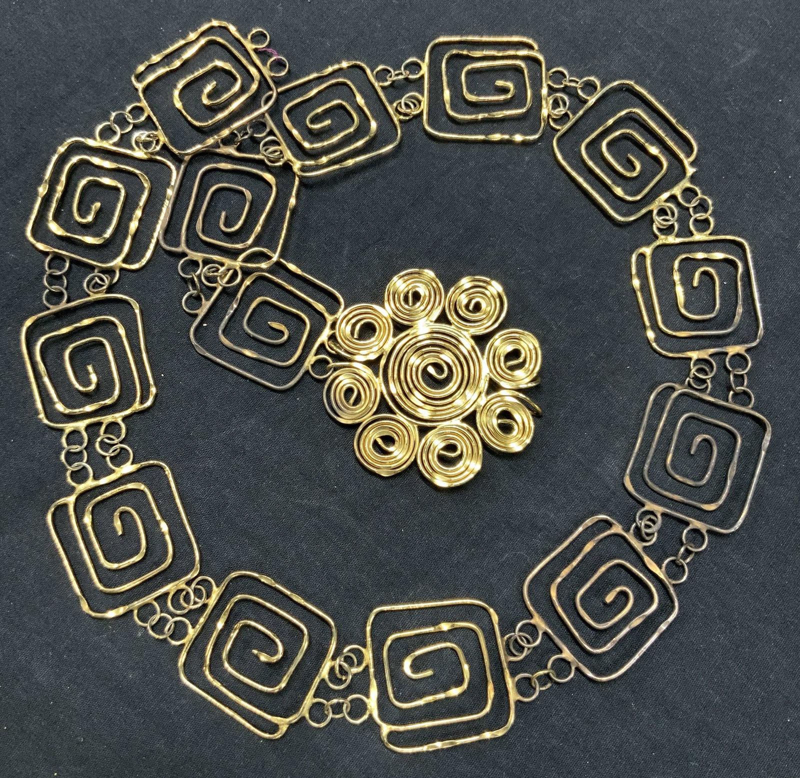 Vintage Floral Arts & Crafts Fashion Belt: Vintage floral shaped, metal crafted fashion belt, gold toned coated crafted metal belt with looped floral center buckle. Approximately 35 inches long with band being,1.75 inches wide and buckle being