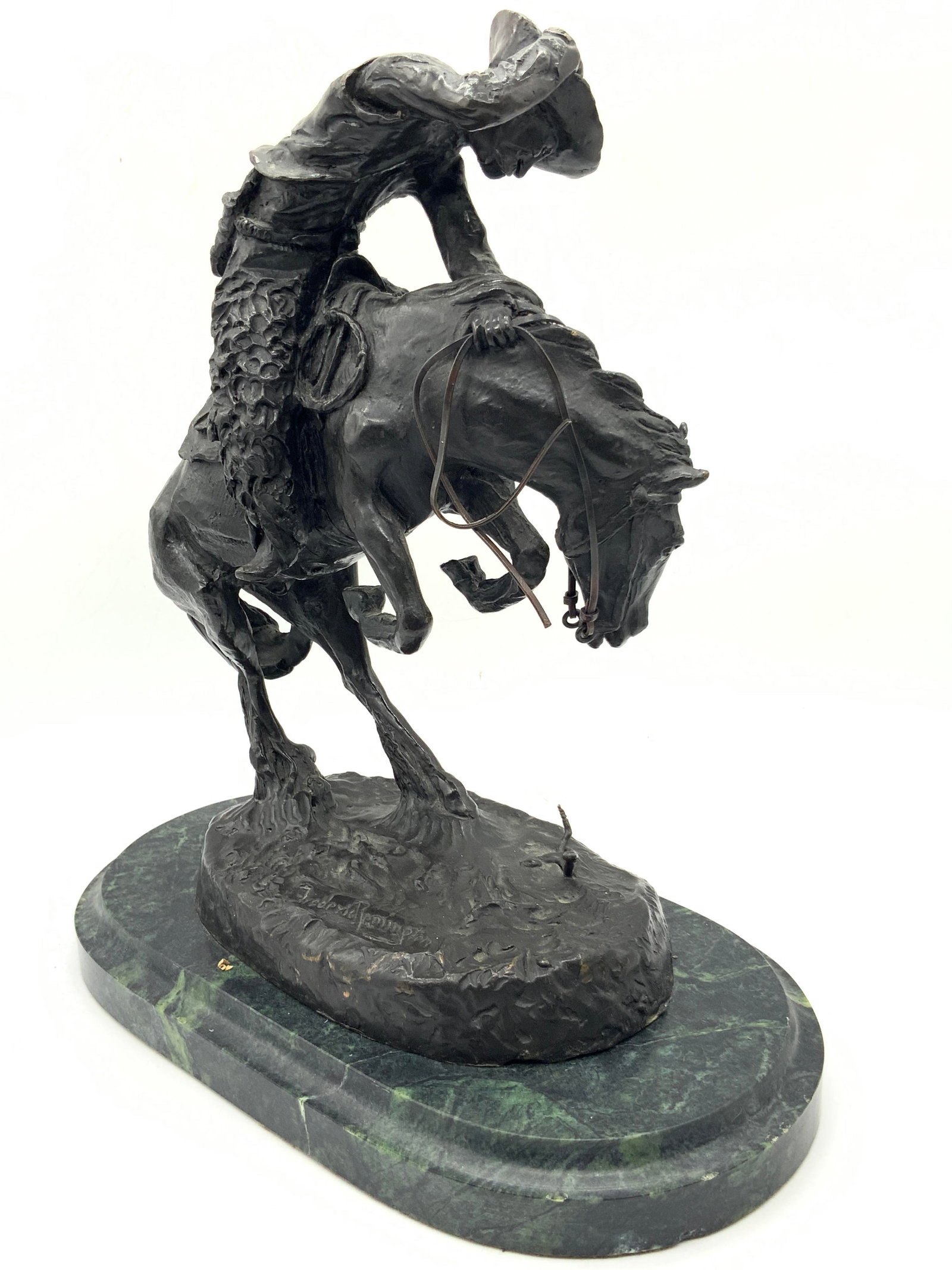 REMINGTON SND Cowboy Bronze & Marble Sculpture: Signed on base Frederic Remington, depicts a cowboy on the back of a bucking horse with a rattlesnake on the ground. Bronze sculpture is affixed to a green marble base. Evident weight. Approximately 1