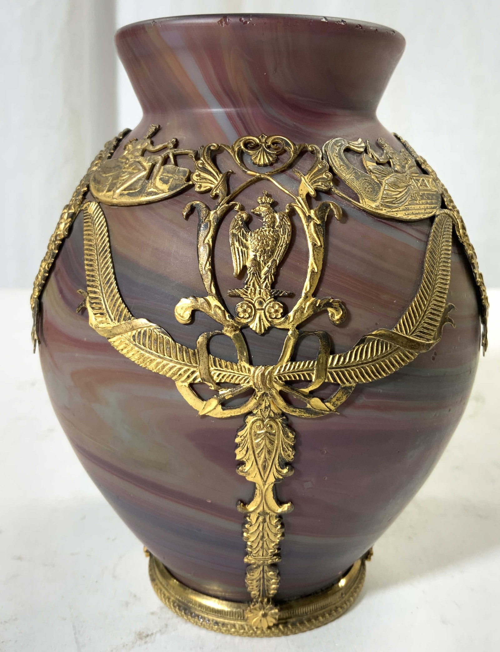 Antqu French 19thC Phoenician Glass Vase W Ormolu: Vase is antique French 19th century. Piece is Phoenician glass with ornate, intricately detailed bronze ormolu overlay. Vase has various maroon tones with banding detail. Mouth of vase flares outward.