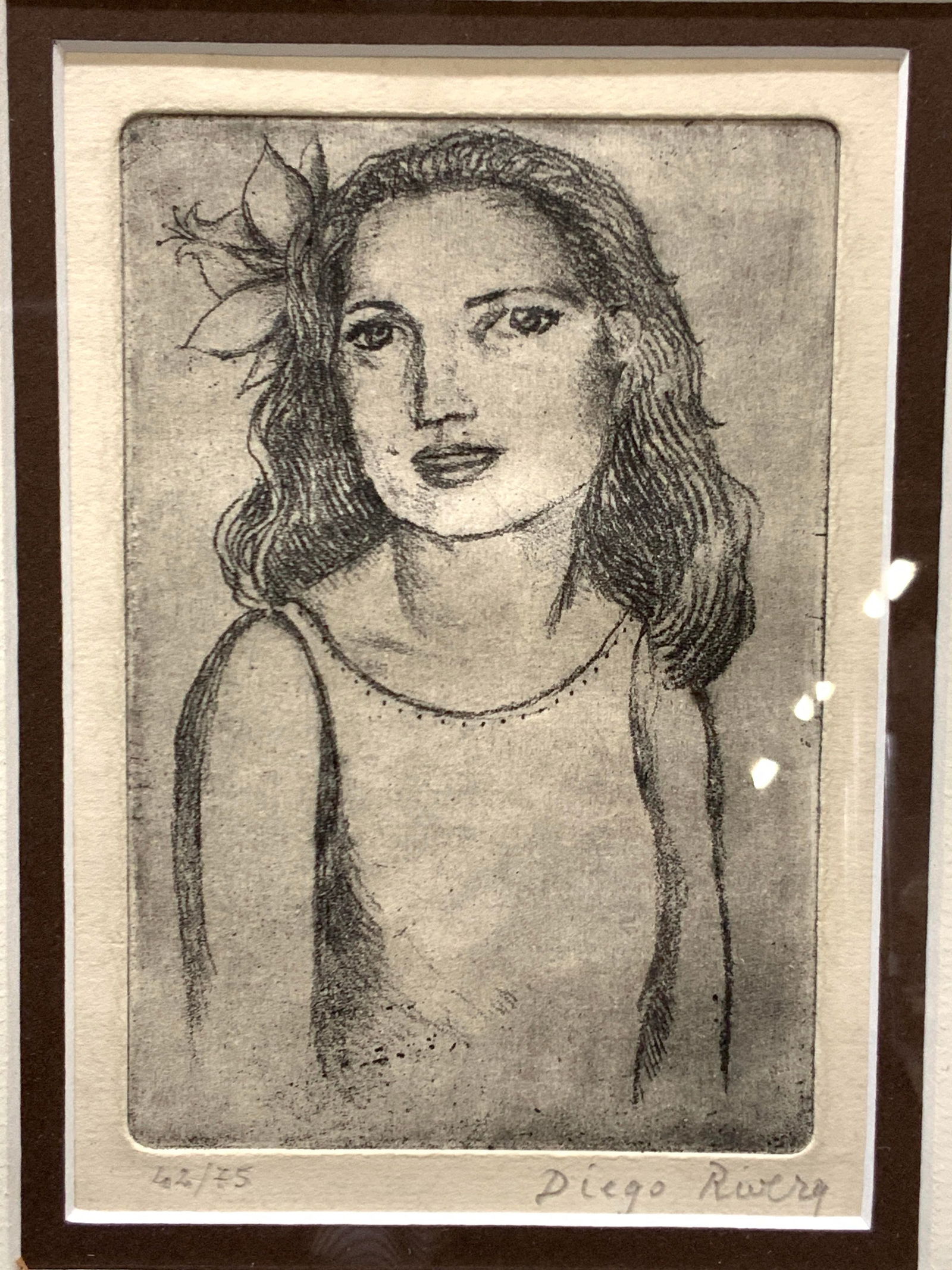 ATTR Diego Rivera Sgd Girl Plate Engraving: Signed in lower right corner in graphite, Diego Rivera, 42/75 Subject depicts a girl with a flower in her hair and looking towards the viewer Framed in Dark toned Woden frame with off white and brown