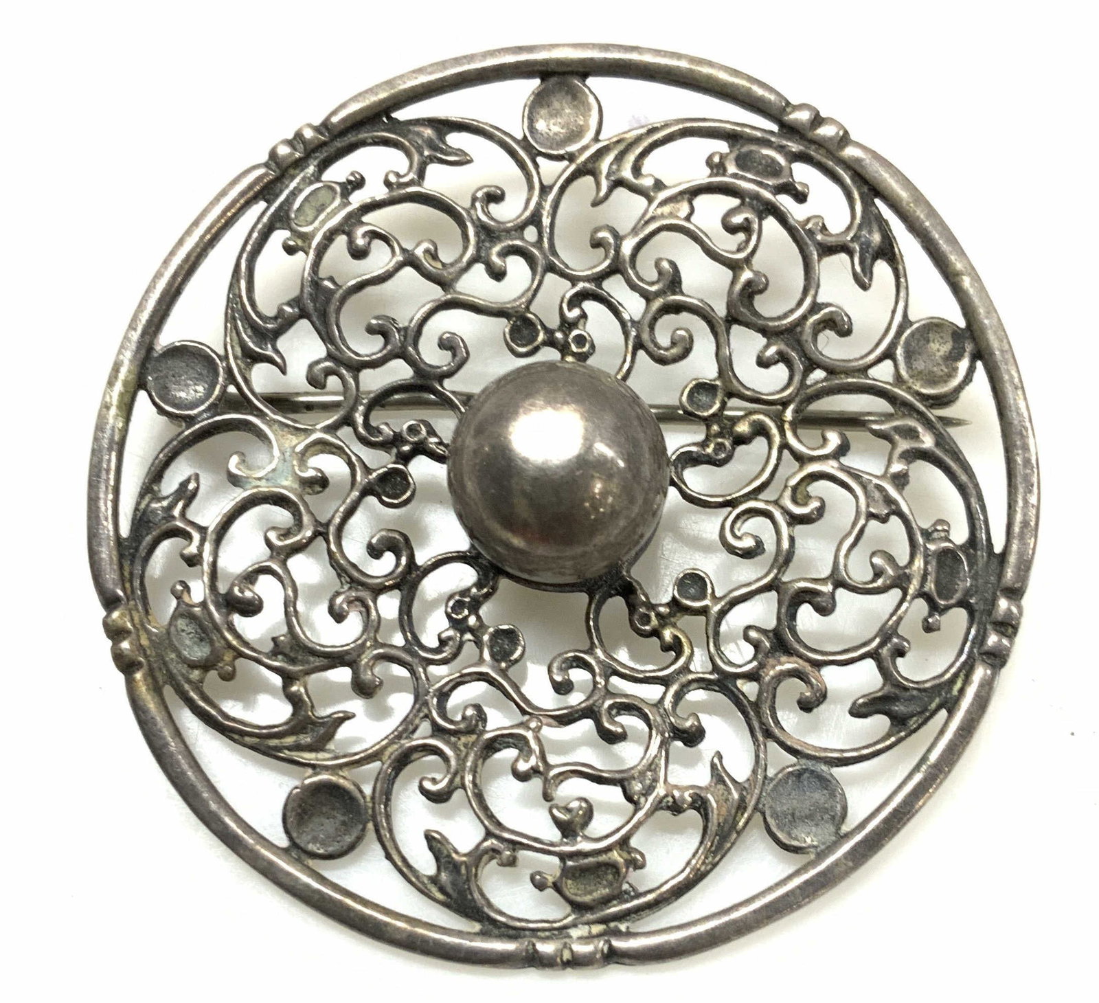 Antique Sterling Silver Victorian Brooch: Round Brooch with pierced scrolling design, hand crafted sterling silver. Tests positive for sterling silver using puritest kit. No hallmark found. Measures 2 in., diameter. .41 ozt possibly antique o