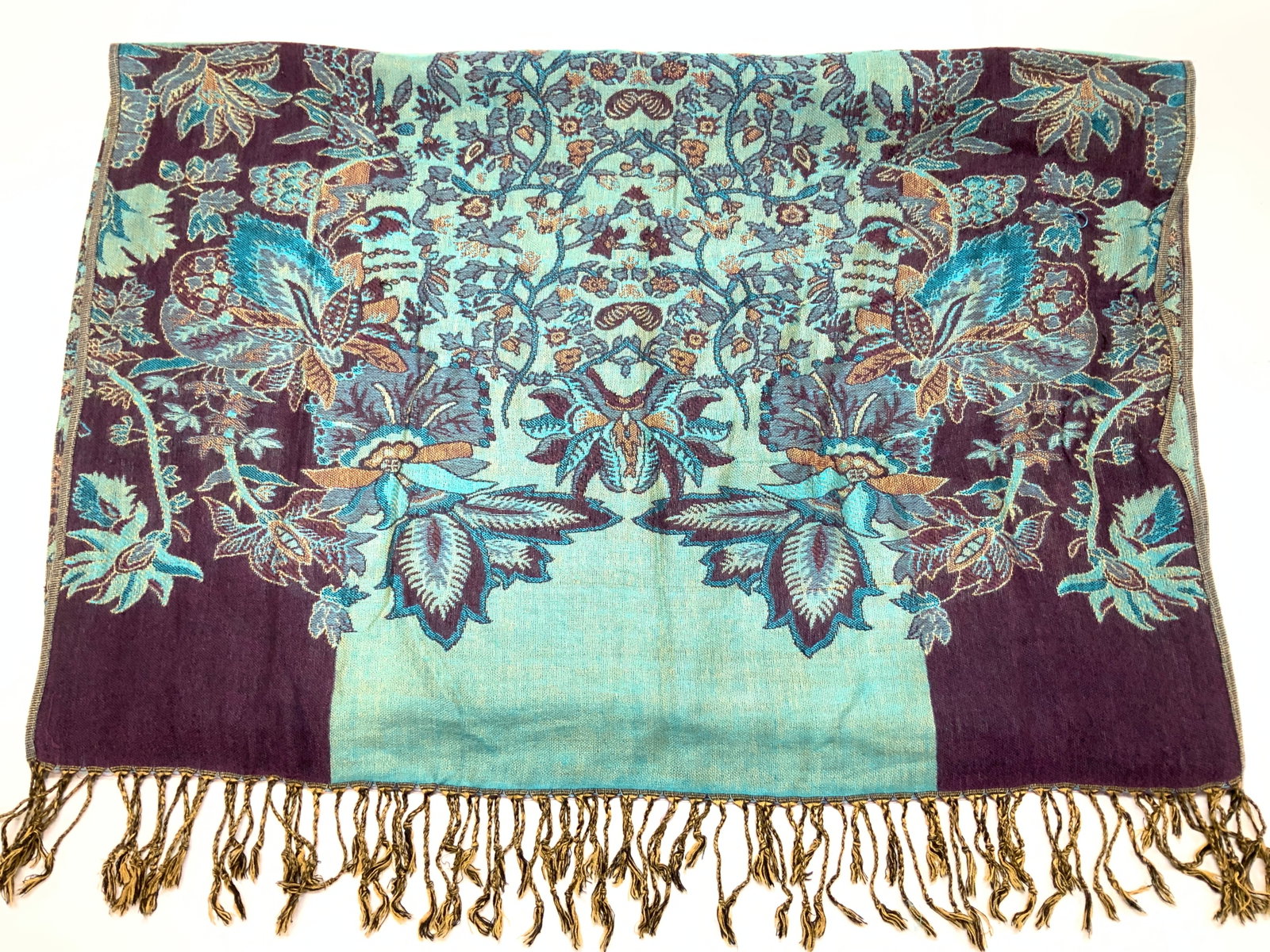 Floral Aqua & Eggplant Tassel Shawl/ Wrap: 27 x 71 in. Shawl , soft hand fabric, possibly acrylic. Aqua and eggplant are the primary colors . Floral vine design. End tassels.1 thread pull notes. Shawl, Floral Shawl, Tassel wrap, clothing acces