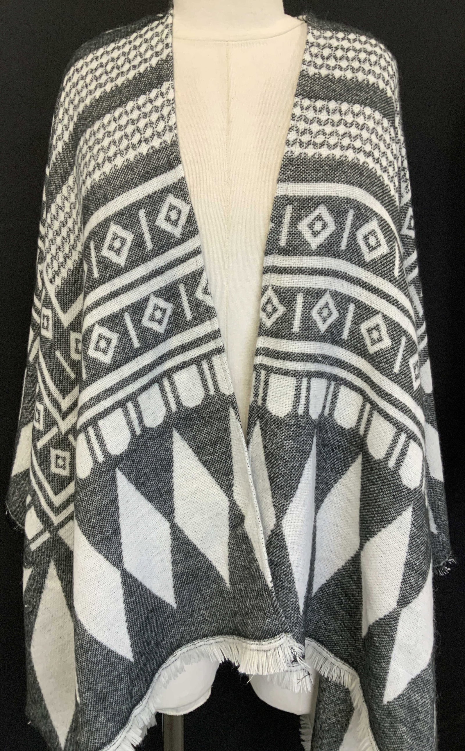 Black and White Geometric Shawl Cape: Soft hand fabric cape with fringe, black and white geometric design, one size fits most. Length depends on fit . Front 28 in. Long, sides 38 in. Long, back 29 in. Long. 71 in. Wide. Fall Spring outerw