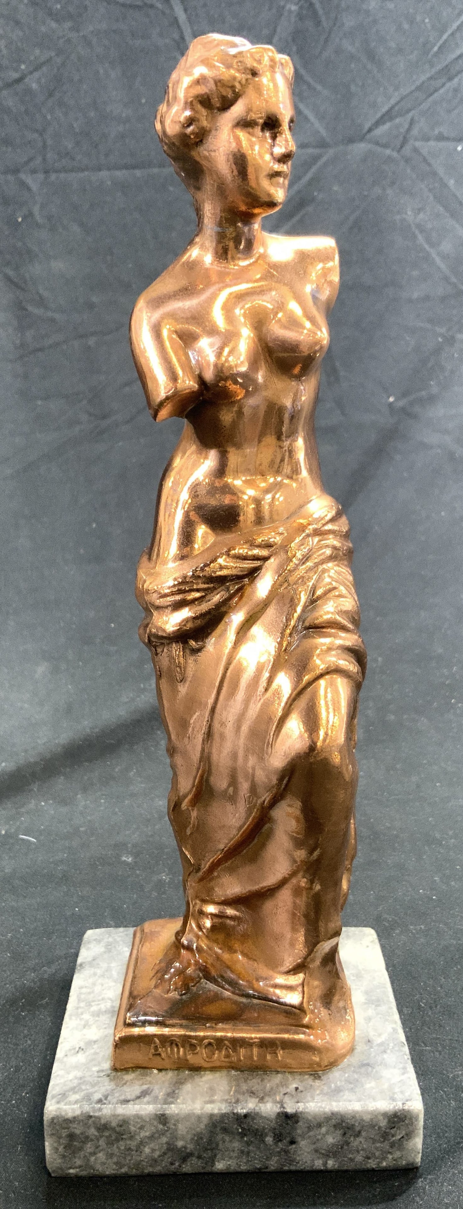 Copper Venus de Milo Sculpt of Greek Goddess: Copper Aphrodite, "Venus de Milo" sculpture of Greek Goddess Aphrodite. Piece is copper depicts partial nude female figure Goddess Aphrodite. Base appears to be marble, possibly stone. Measures approx