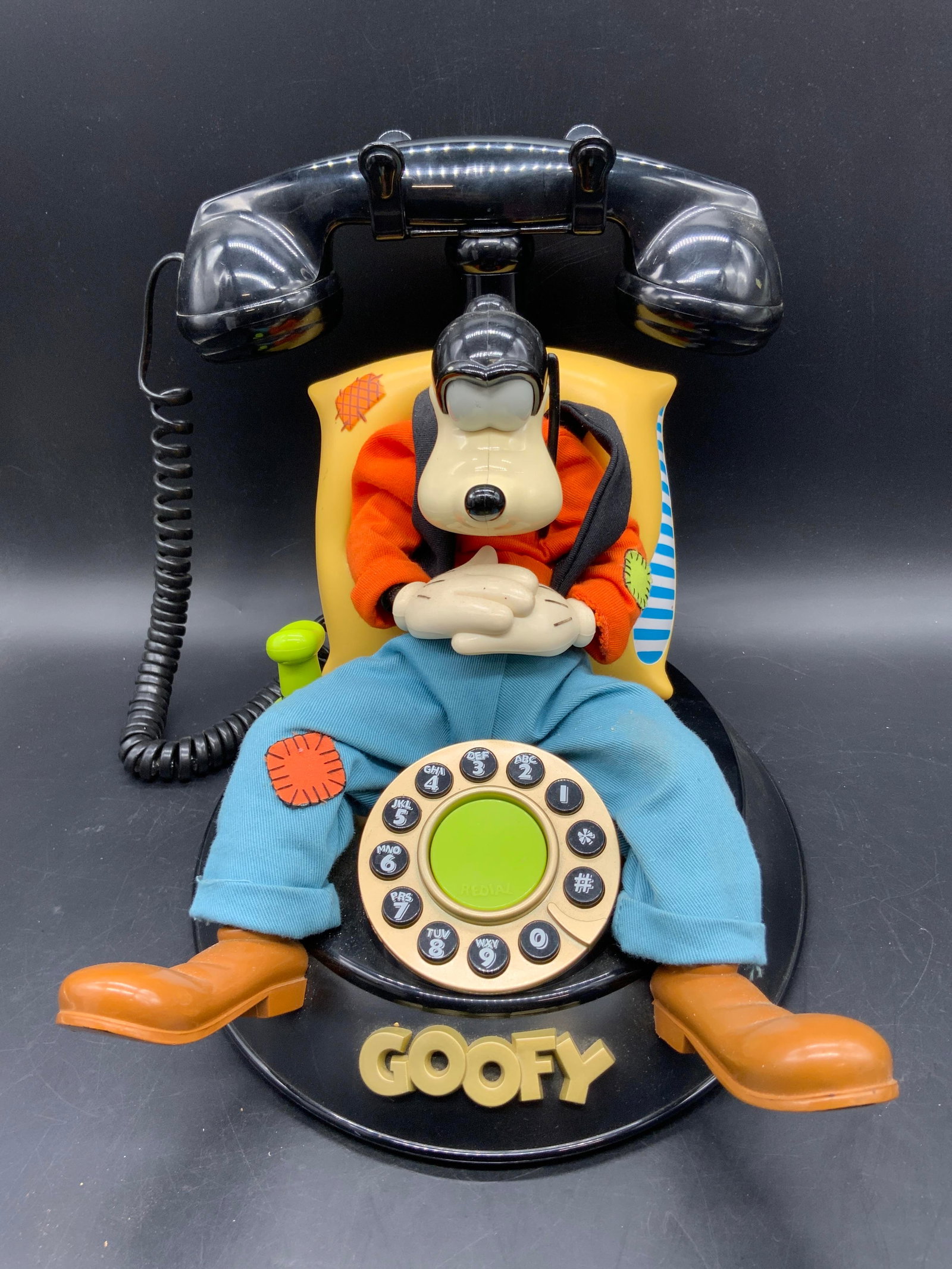 GOOFY TELEMANIA Vintage Telephone, Segan Product: A vintage Goofy telephone. Crafted from composite, fabric, and metal parts. Piece appears to be articulated. Underside reads: A Segan Product, created and designed by MH SEGAN LP. Goofy Telephone. Tel