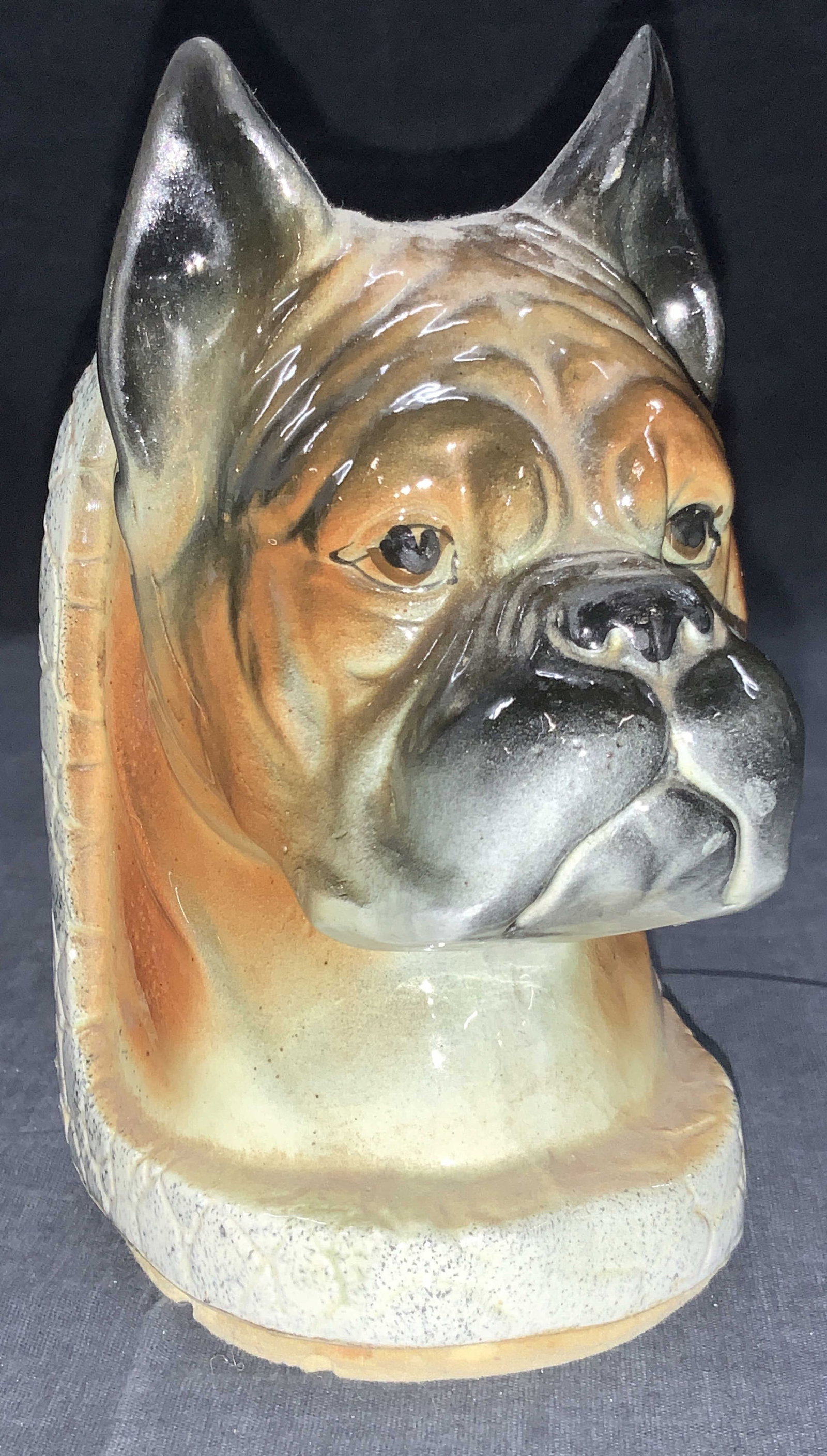 Ceramic Made Boxer Dog Bookend: Ceramic made Boxer Bookend with the head of a Boxer complete with pointed ears. Corked underside holds rice. Approximately 6.5 inches tall and 3 inches wide. Minor wearing to ceramics due to age ad us
