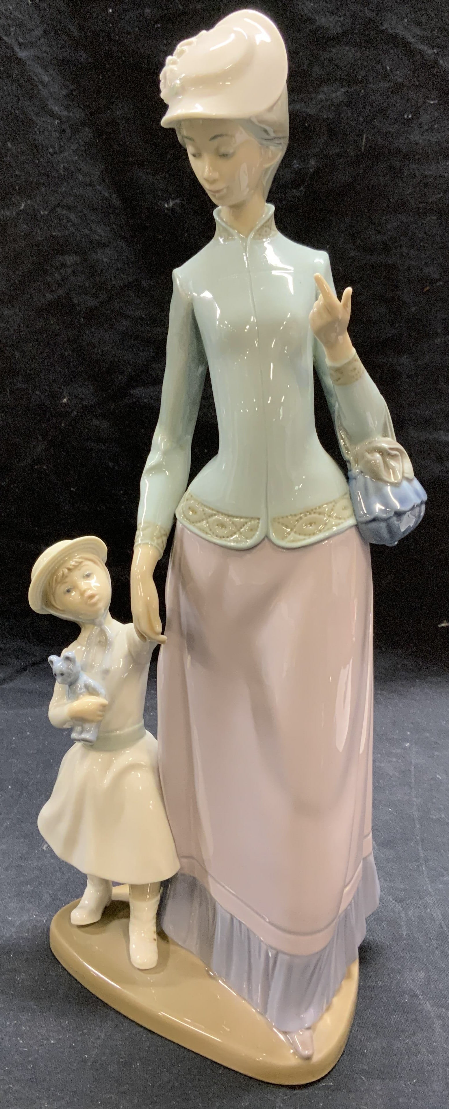 Lladro Mother & Child Porcelain Figurine, Spain: Lladro 1353 mother and child porcelain figurine. Made in Spain. Trademarked to underside. Some surface wear consistent with exposure. Chipped to finger. Measures approx. 5.5 x 14 inches. Lladro, lladr