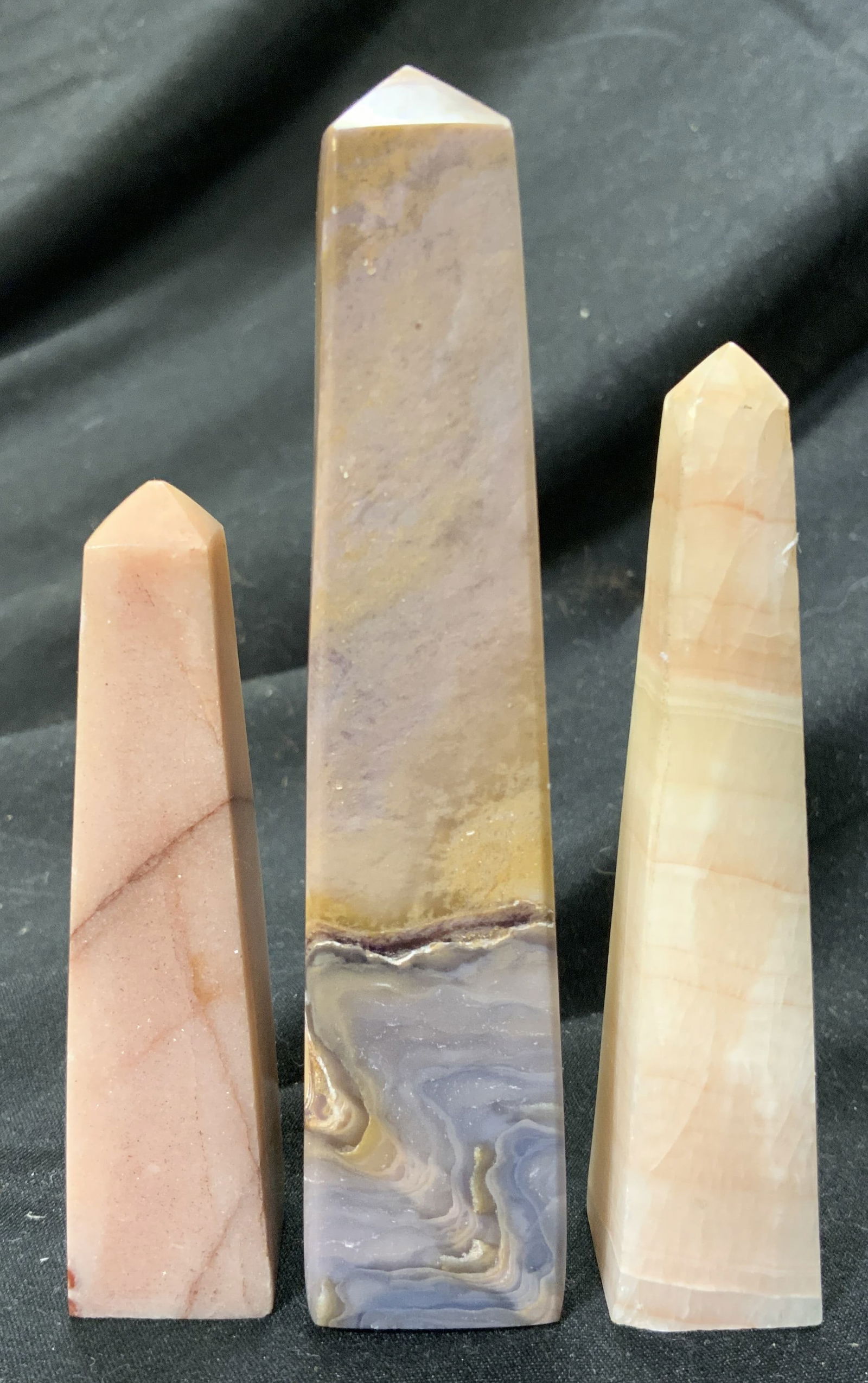 Group Lot 3 Natural Stone Agate Obelisks: Obelisk figures are natural stone appear to be agate. Each have tan toned banding. Largest piece in lot measures approx 4.25 inches tall 1 inch square at base. Obelisks, obelisk figures, natural stone