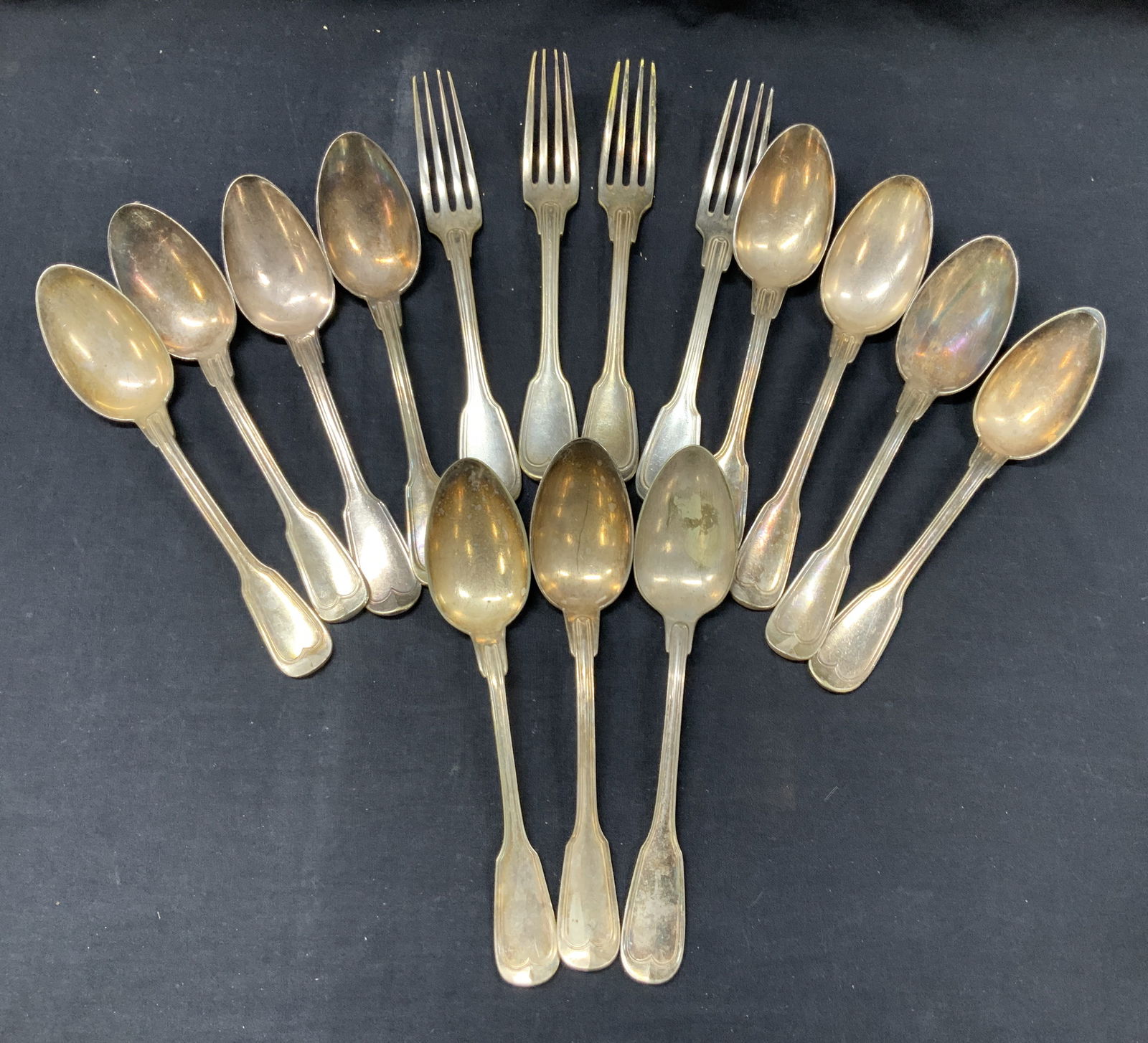 Lot 15 Silver Plate Over Brass Forks & Spoons: Lot of 15 silver plated spoons and forks. 11 table spoons and 4 dinner forks. Spoons are stamped on backsides with makers marks, 53s, while the forks are stamped 58' Thouret. Forks are approx 8.75 inc