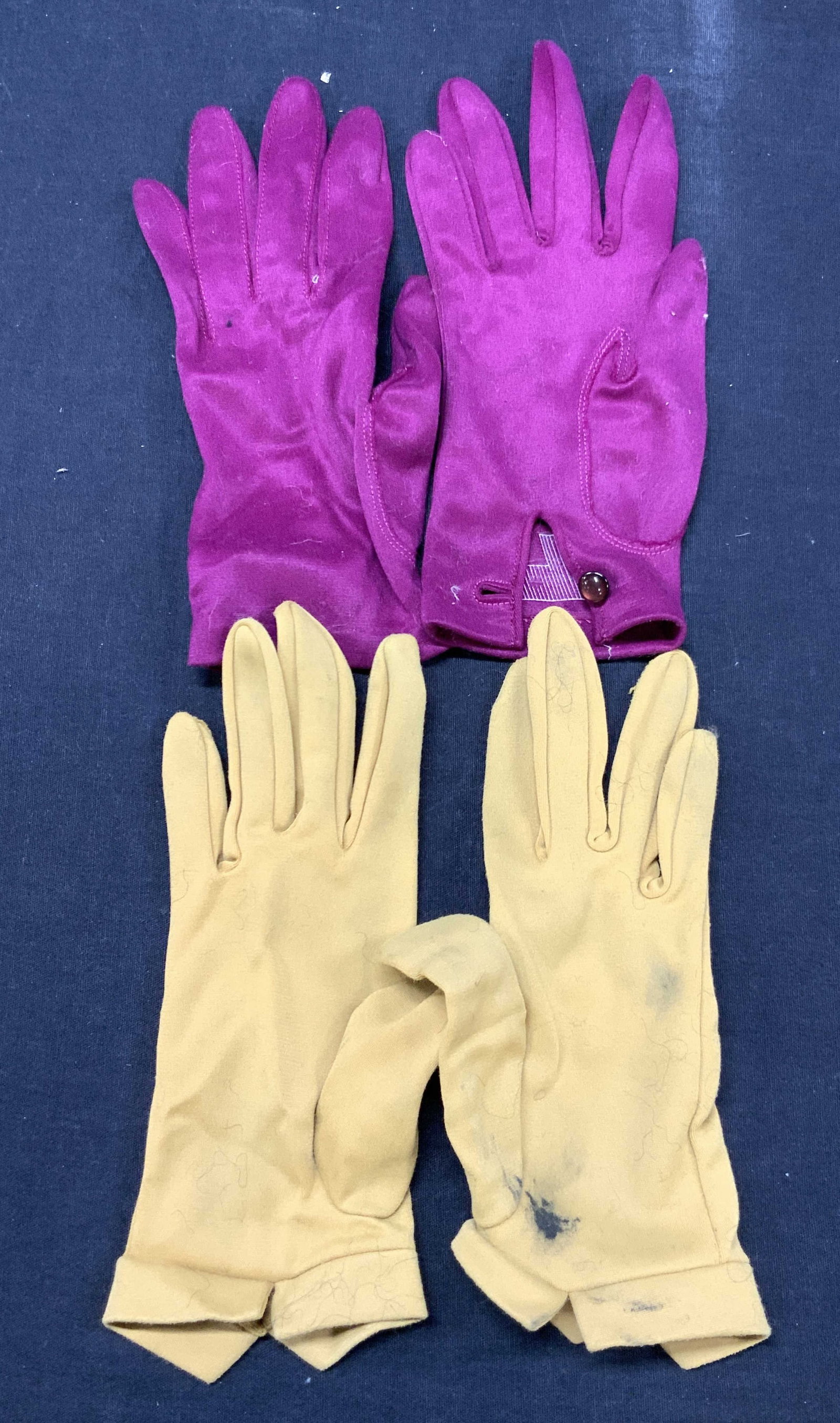 2 Pairs Soldi Color Van Raalte Gloves: Lot of 2 pairs of solid colored gloves. 1 pair of mustard yellow toned gloves, marked on interior Van Raalte, all nylon. Approx 8.25 inches long and 3.25 inch diameter at wrist and 1 pair of magenta t
