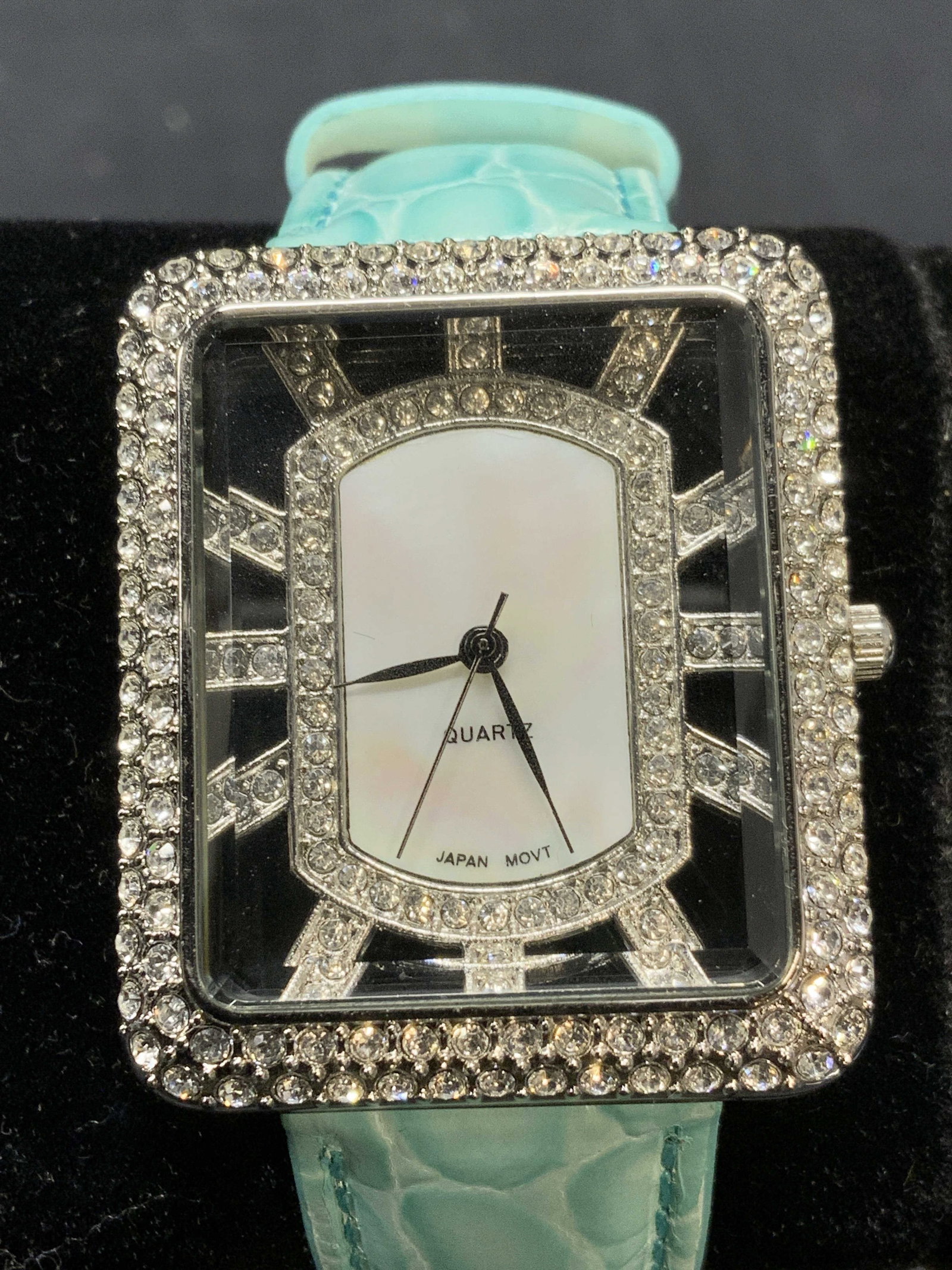 ADRIENNE Blue Leather Strap Crystal Watch: Adrienne blue Croc embossed leather strap watch with pave crystal decorated watch face. Signed Adrienne to underside. Marked stainless steel back, Japan movement. Watch face measures approx. 1.5 x 1.2