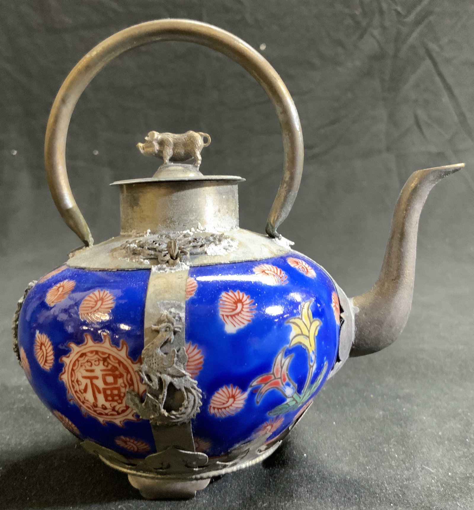Vintage Hand Crafted Porcelain Asian Teapot: Asian teapot with Hand painted porcelain in royal blue with Rusty orange . Tibetan metal handiwork featuring Chinese dragons and pig figurine finial., total width 3.75 in. Total height 5.25 in. 5 inch