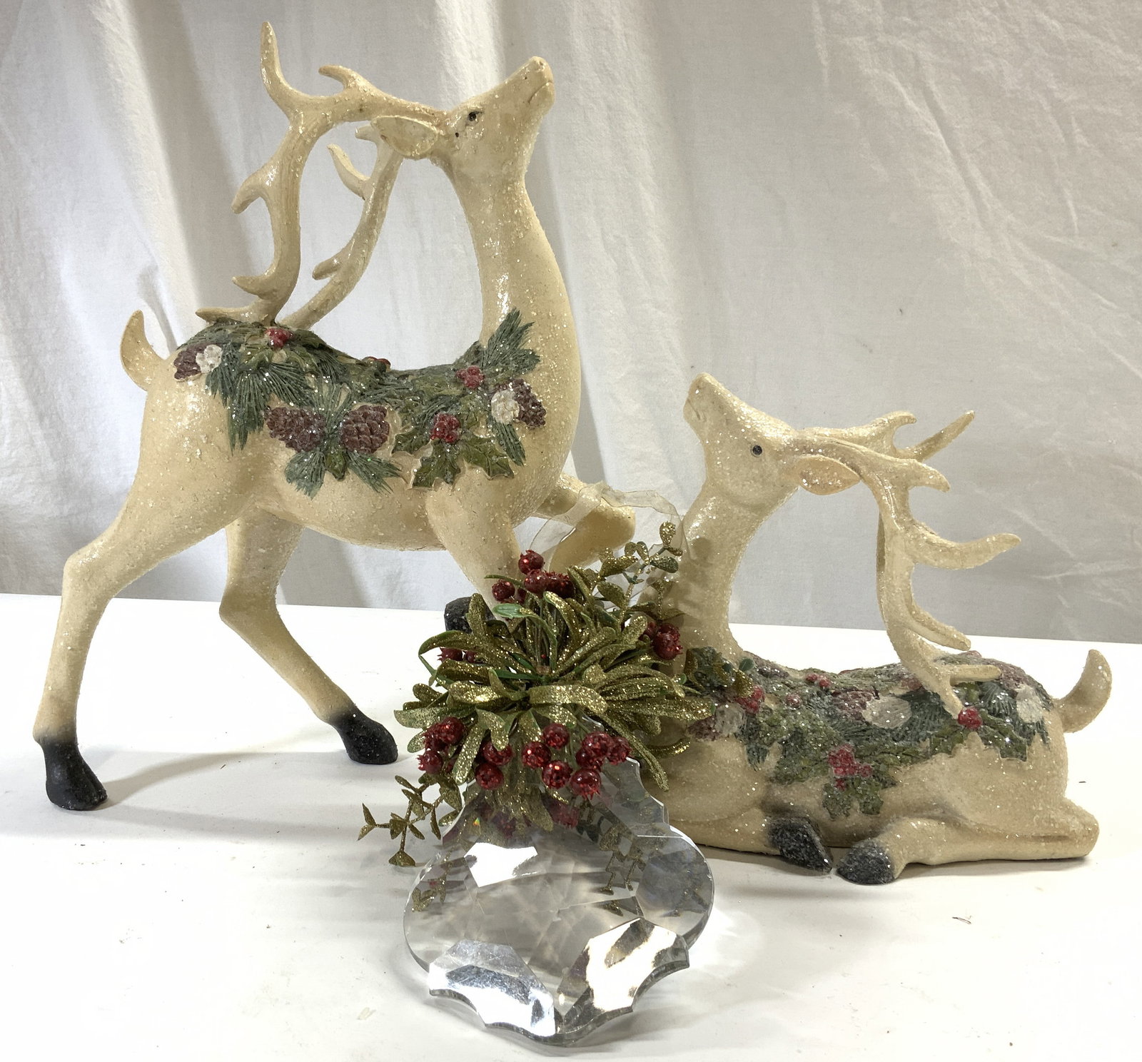 Lot 3 Polystone Deer Figures & Acrylic Ornament: Lot includes 2 deer figures, appear to be polystone, possibly wooden. Depicts 1 seated & 1 standing with hoof raised and 1 glass ornament with floral and leaf detail. Largest Reindeer figure measures 