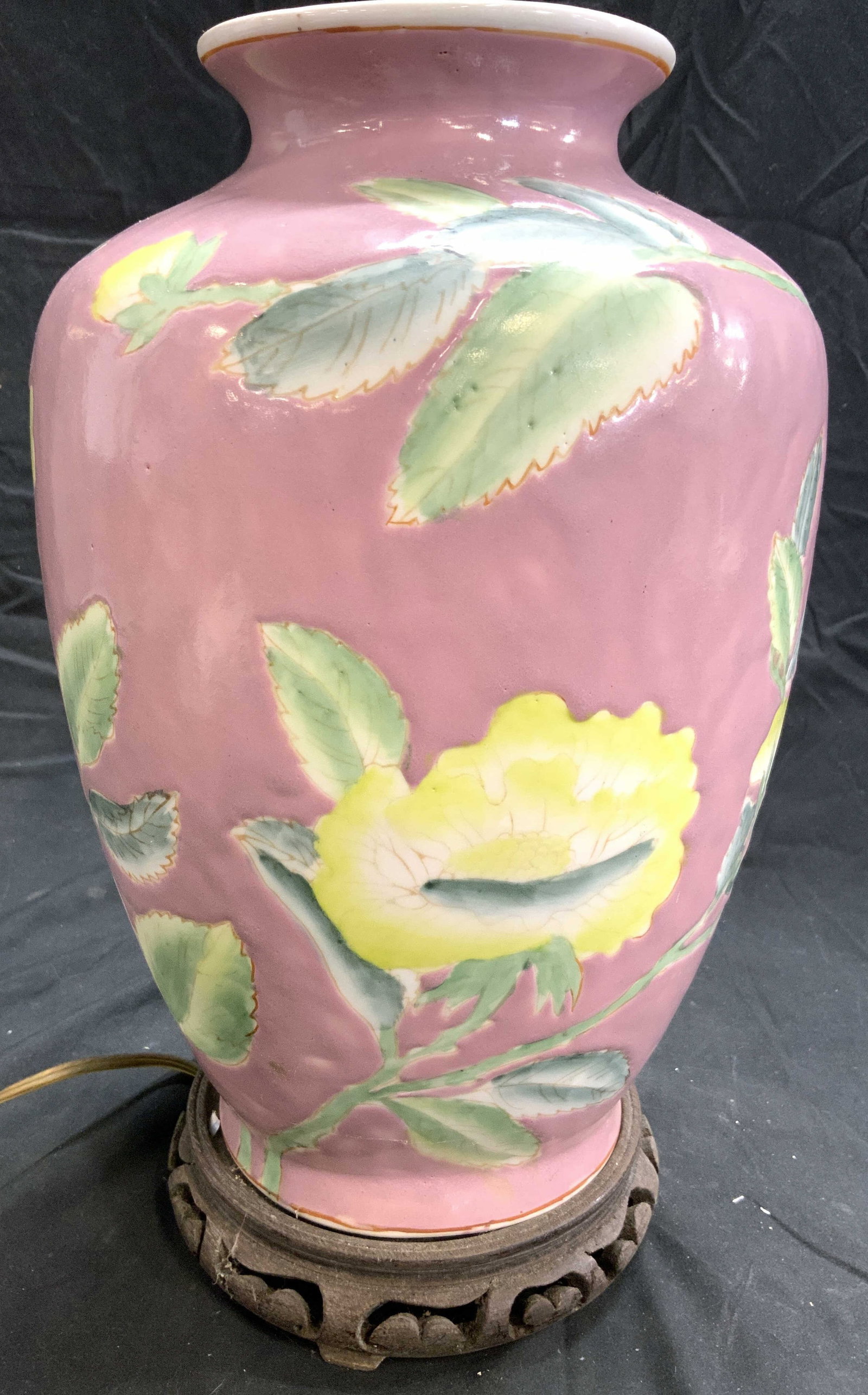 Vintage Hand Painted Asian Porcelain Lamp: Lamp is vintage. Piece is porcelain. Lamp is hand painted with multi toned detail floral and leaf detail. Piece has carved wooden base with pierced detail. Lamp includes harp and finial. Measures appr