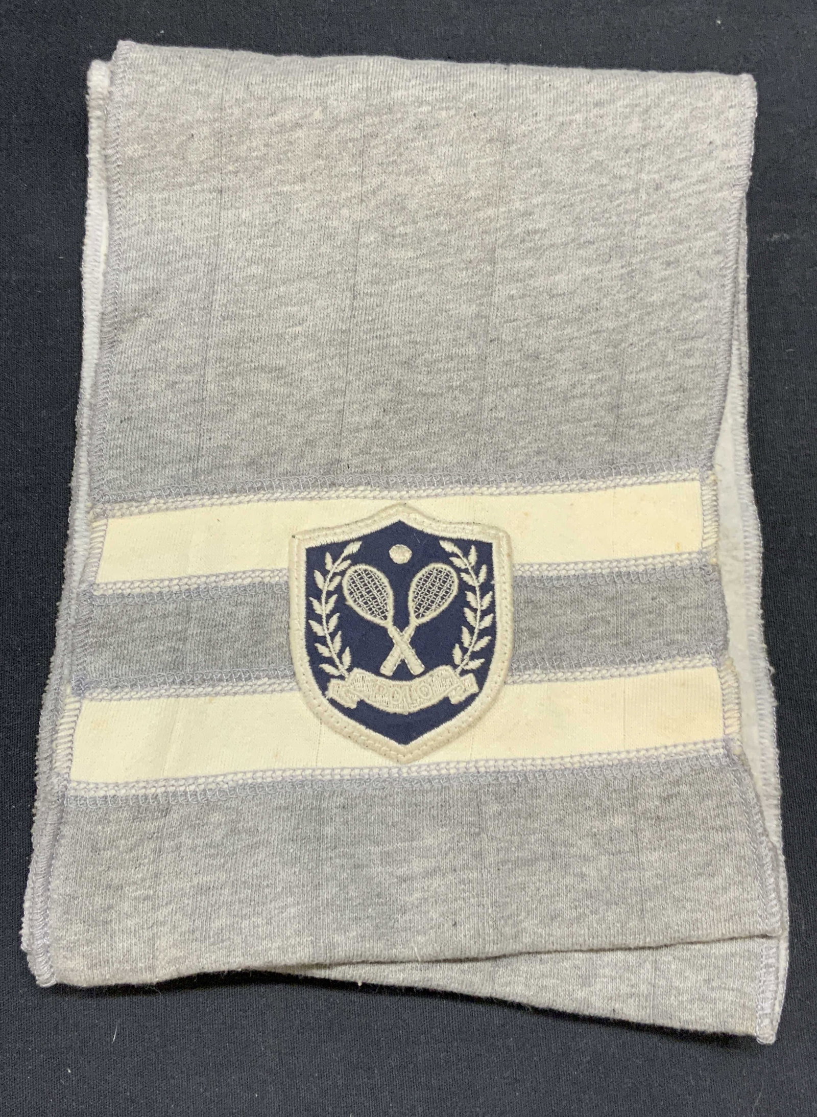 Ralph Lauren Gray Cotton Blend Tennis Scarf: Ralph Lauren gray cotton blend scarf with Tennis motif patch. Designer label on tag. Measures approx. 38 inches long. Some wear to material including blemishes observed. Ralph Lauren, Ralph Lauren sca