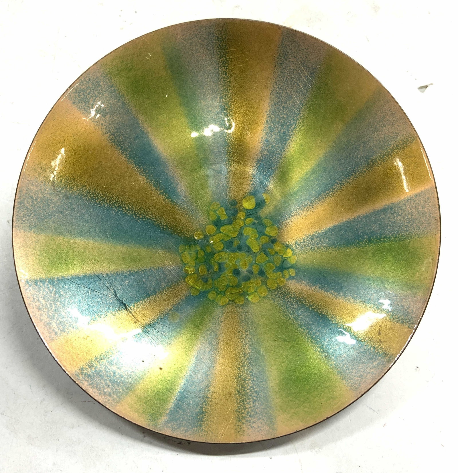 BOVANO Hand Crafted Enameled Metal Plate: Tag on Underside reads Hand Crafted By BOVANO OF CHESHIRE CONN. Plate is enamel on metal. Piece has green, blue & gold toned. Plate measures approx 9 inches diameter. Plate, enameled plate, metal plat