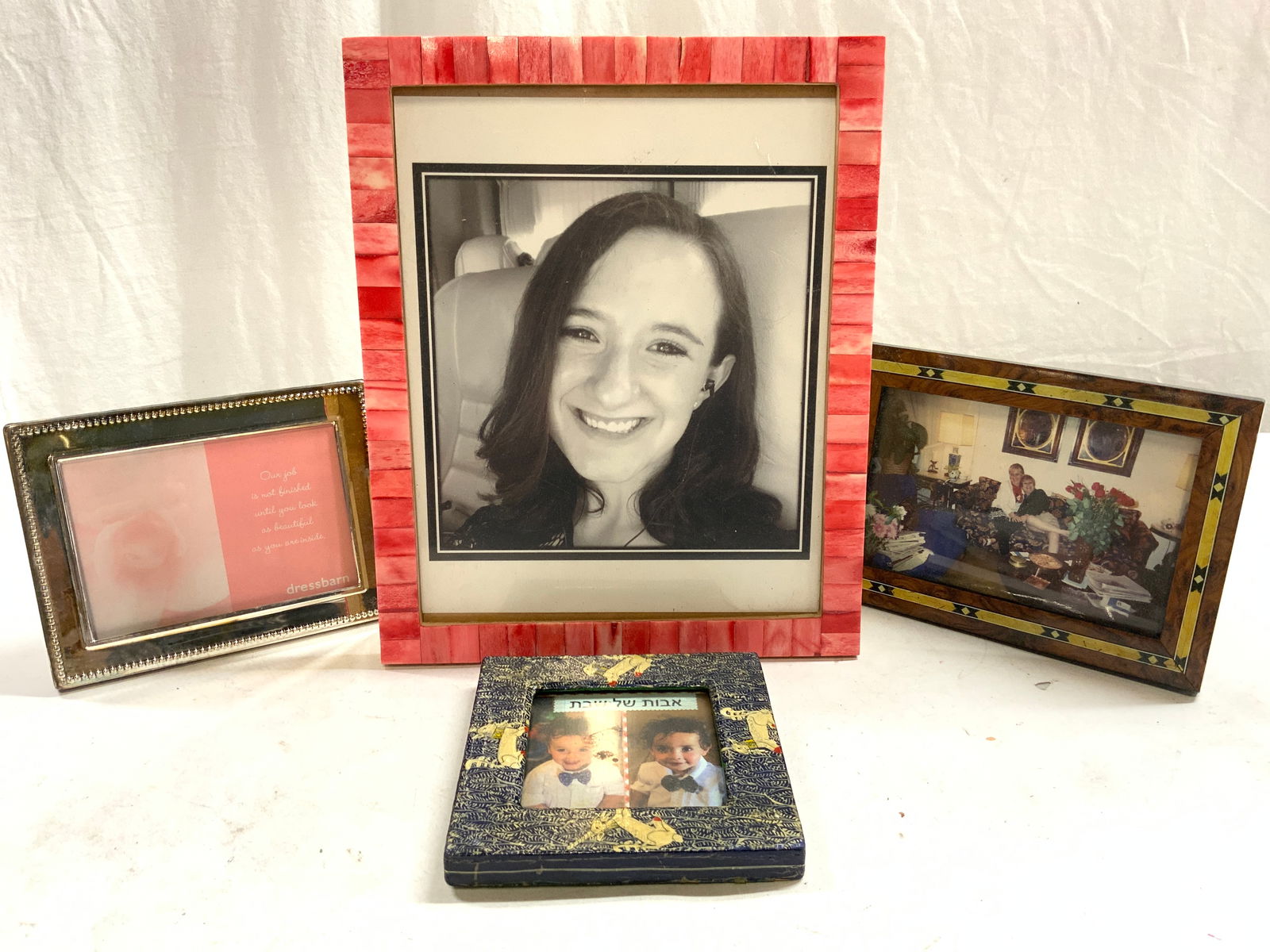 Lot 4 Assorted Picture Frames: Lot includes 4 picture frames, 1 wooden with reindeer detail, 1 which appears to be wooden possibly veneer, 1 pink toned bone mosaic, & 1 white metal frame. Largest frame measures approx 11 inches tal