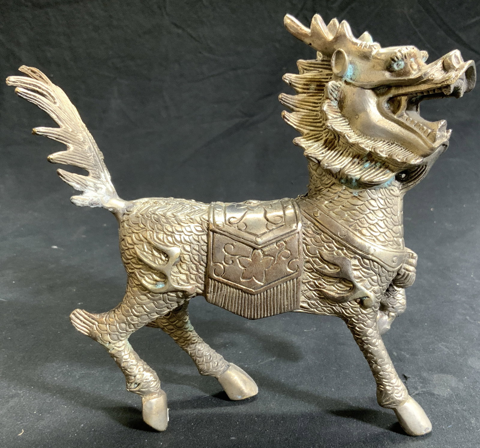 Vintage Asian Silvered Brass Quilin / Temple Lion: Temple lion figure appears to be silvered brass. Piece depicts a galloping quilin / temple lion figure with mouth open. Figure has intricate relief detail. Piece measures approximately 7 inches tall a