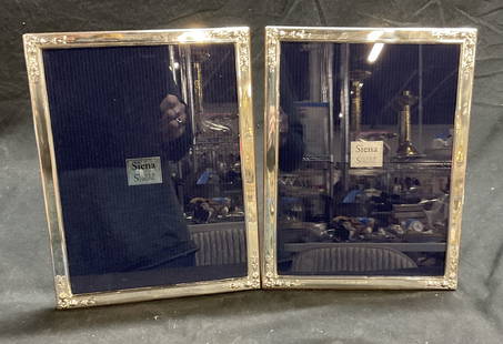 Lot 2 Siena Sterling Silver Picture Frames: Two Siena Sterling Silver Picture Frames with floral corner design. Wood back and two-way easel with metal hinge. Measures approx. 10.5H x 8W in. Some surface wear consistent with age and use. Some sc