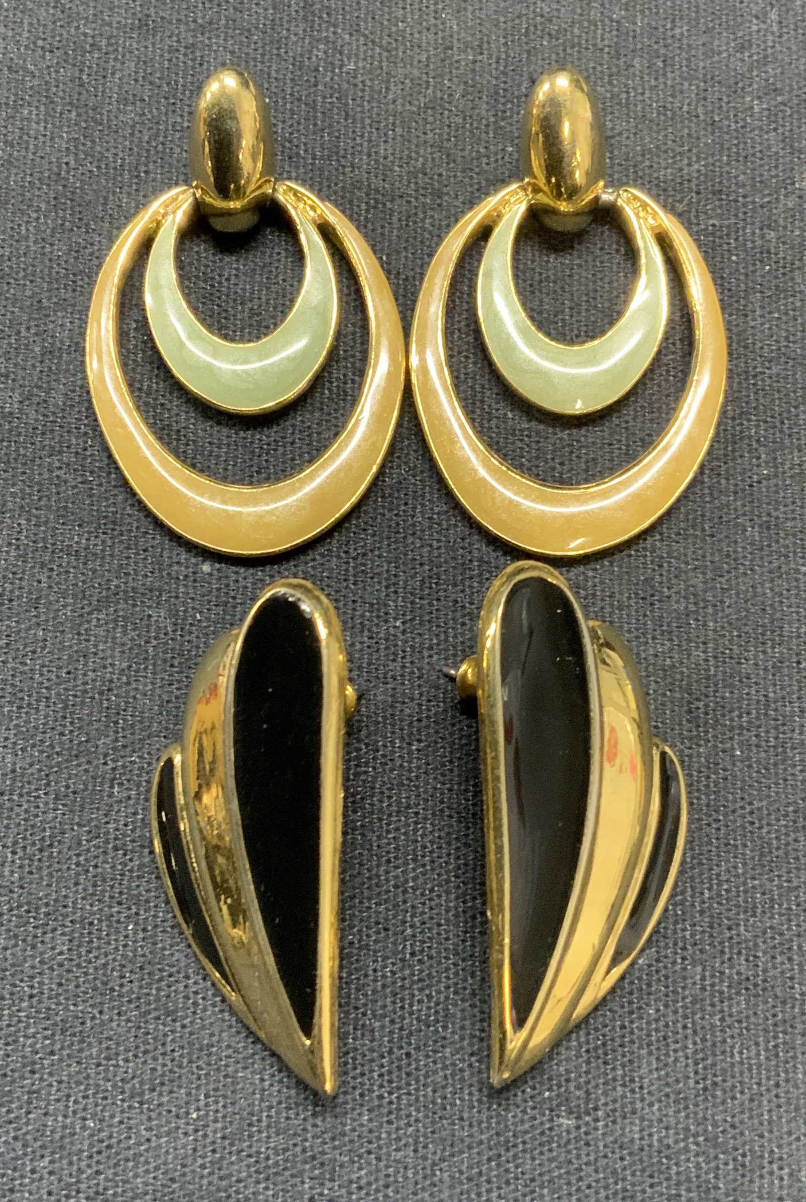 Lot 2 Trifari Gold Tone Enameled Earrings: Lot of 2 jewelry pieces. Trifari gold tone and black enameled earrings. Signed to reverse. Post backings. Measure approx. 1 3/8 x 5/8 inches. Trifari gold tone green and beige enameled dangle earrings