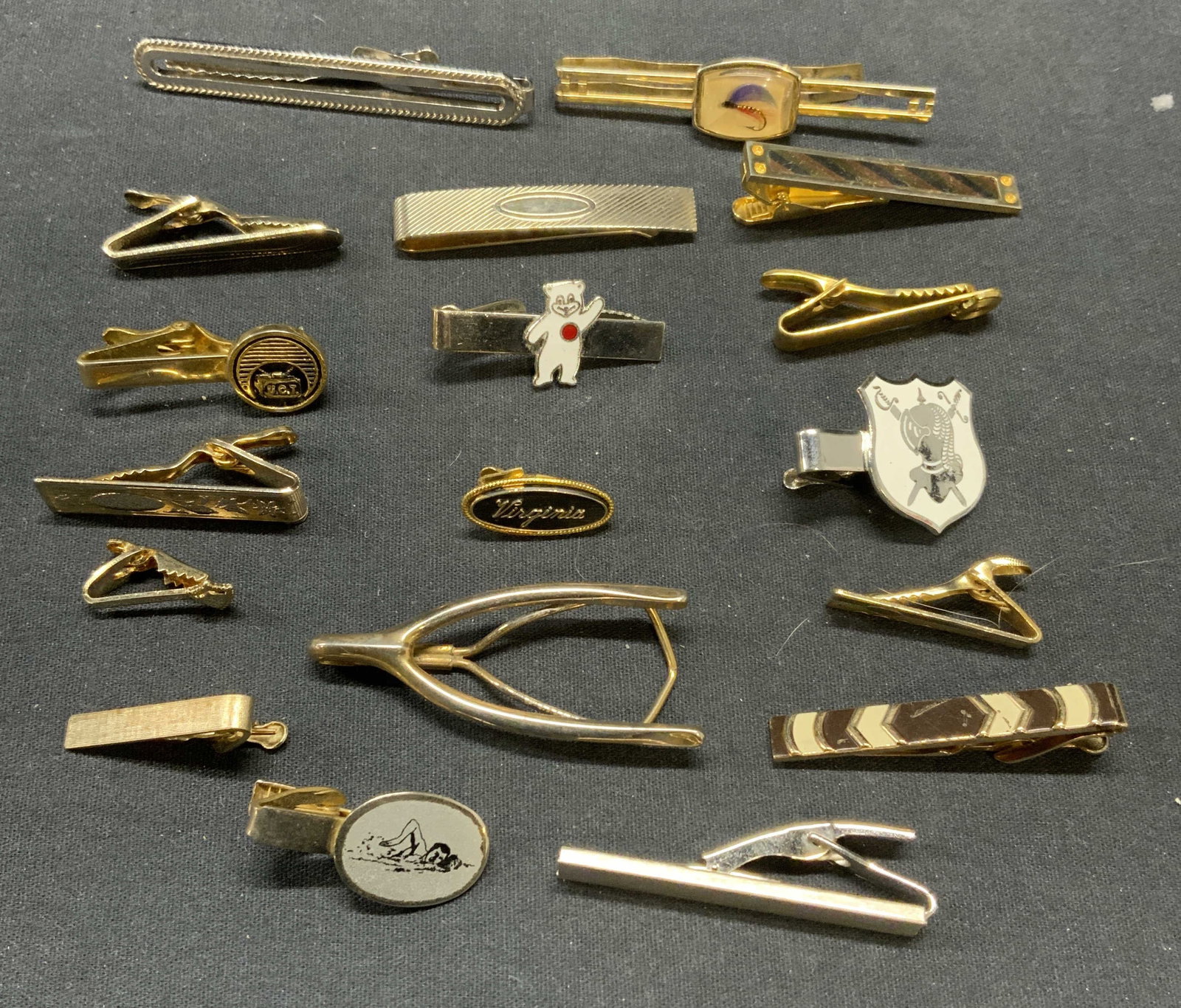 18 Swank, Shields, Anson More, Tie Clips: Lot of 18 silver and gold tone tie clips. 2 Swank enamel decorated and wish bone shaped tie clips. 1 Shields brushed gold tone tie clip. 1 Jamiban enameled tie clip. 1 Sarah Coventry silver tone tie c