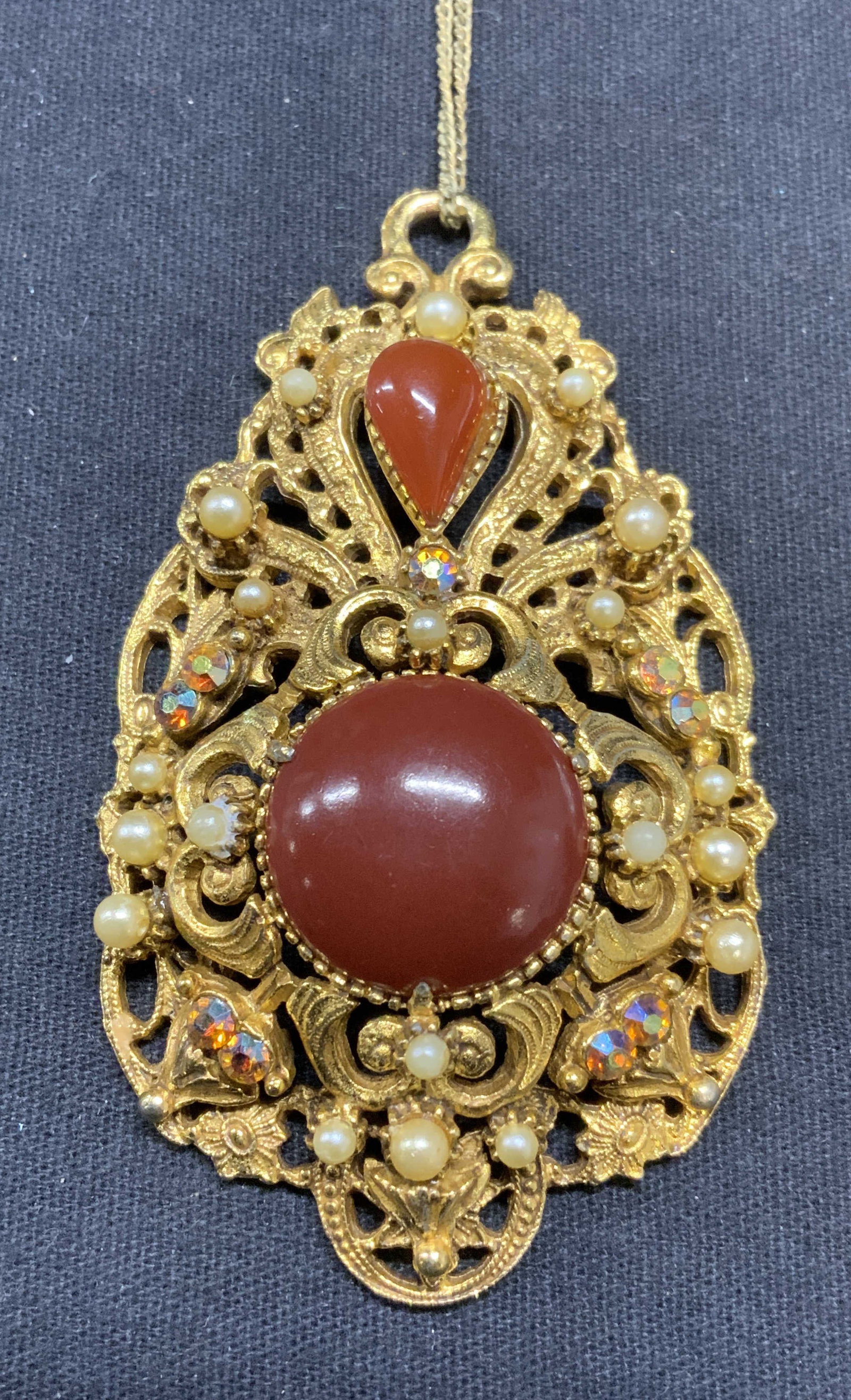 FLORENZA Gold Tn Red Cabochon Pendant Necklace: Vintage FLORENZA gold tone pendant necklace with red Cabochon, faux pearl, and crystal decoration. Signed to underside of pendant. Necklace drop length approx. 8.75 inches. Pendant measures approx. 2.
