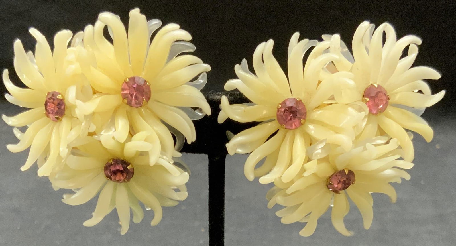 KRAMER White Flower Pink Crystal Earrings 2in: Kramer white silicone sculptural clip on earrings with pink crystal decoration. Signed to backings. Measure approx. 2 inches diameter. Some surface wear including scratching observed. Estate jewelry,