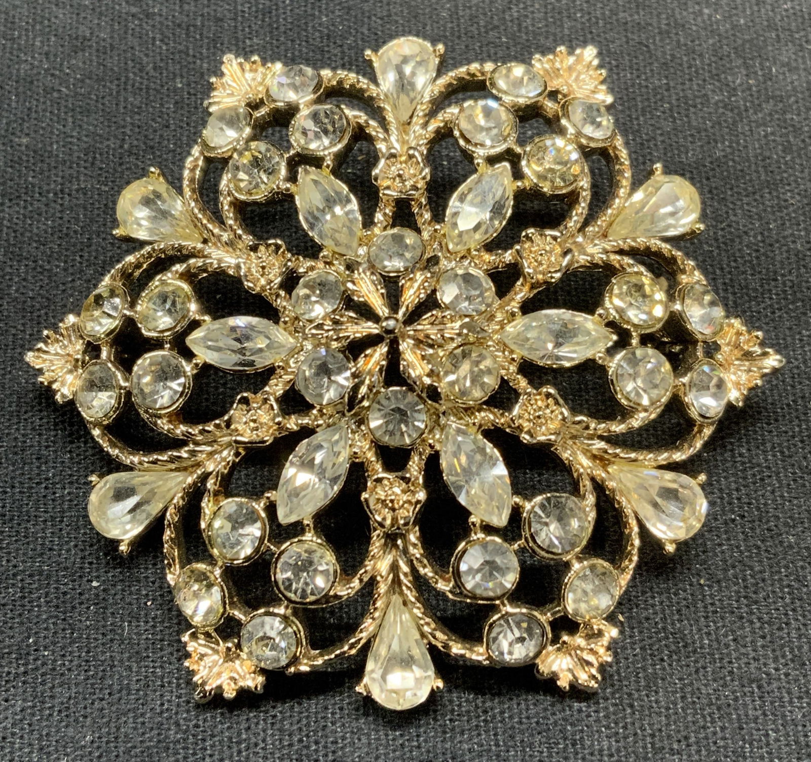 HATTIE CARNEGIE Silver Tn Crystal Flower Brooch: Vintage Hattie Carnegie silver tone crystal decorated flower brooch. Signed to underside. Hinge pin to underside. Measures approx. 2.25 inches diameter. Some surface wear including scratching observed
