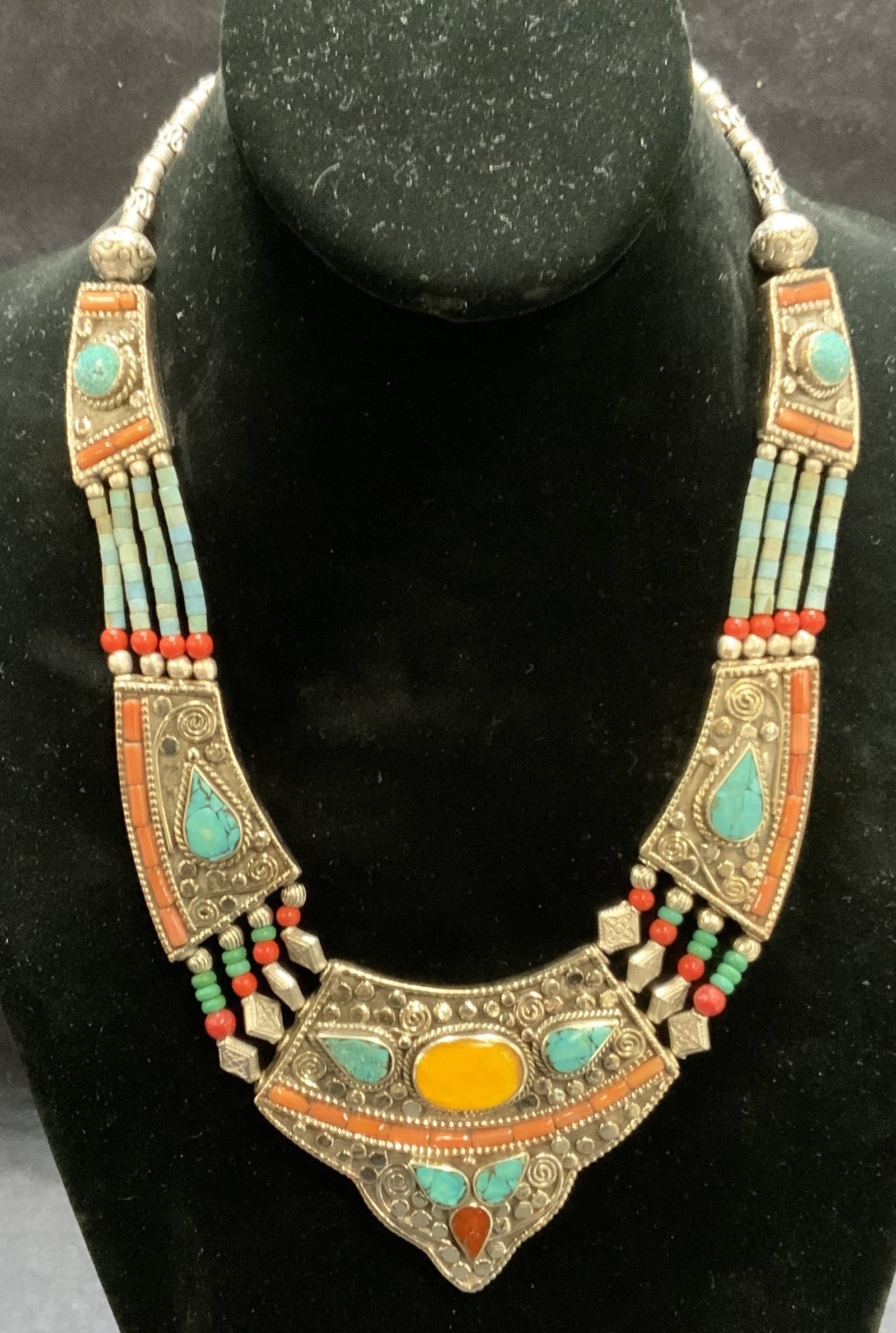 Sterling Silver Turquoise Coral Amber Necklace: Vintage sterling silver necklace with turquoise, coral, and amber decoration. Marked 925 to underside. Drop length approx. 8 inches. Some surface wear including scratching observed. Total weight 149.5