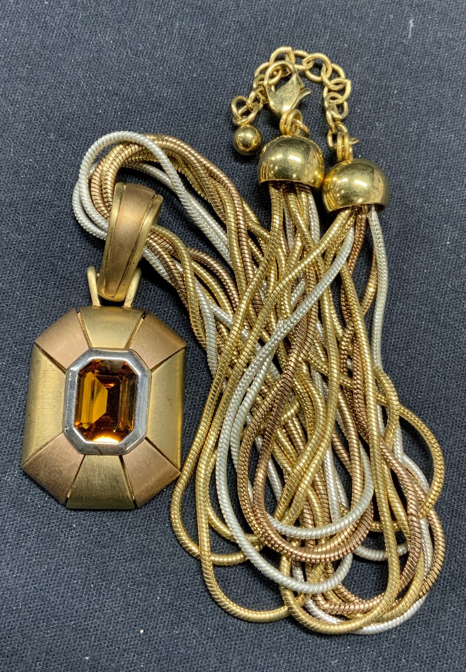 NAPIER Gold Tn Crystal Pendant Necklace: Vintage Napier gold tone multi chain pendant necklace with amber toned crystal. Signed to underside of pendant. Drop length approx. 8.5 inches. Pendant measures approx. 1.5 x 1 inches. Some surface we