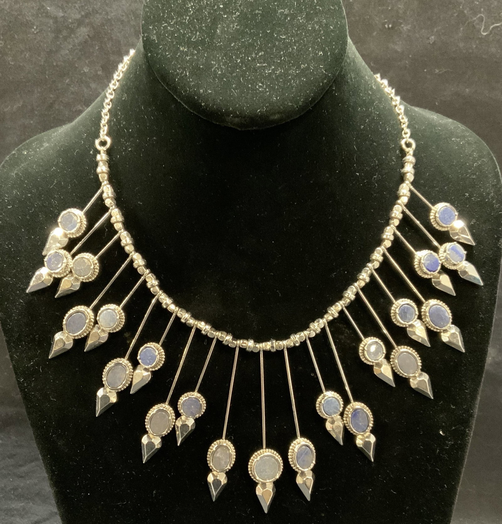 BCBGMAXAZRIA Silver Tn Natural Stone Necklace: BCBGMAXAZRIA silver tone Sunburst necklace with blue natural stone decoration. Signed with necklace charm. Drop length approx. 8 inches. longest pendant measures approx. 2.5 inches. Some surface wear 
