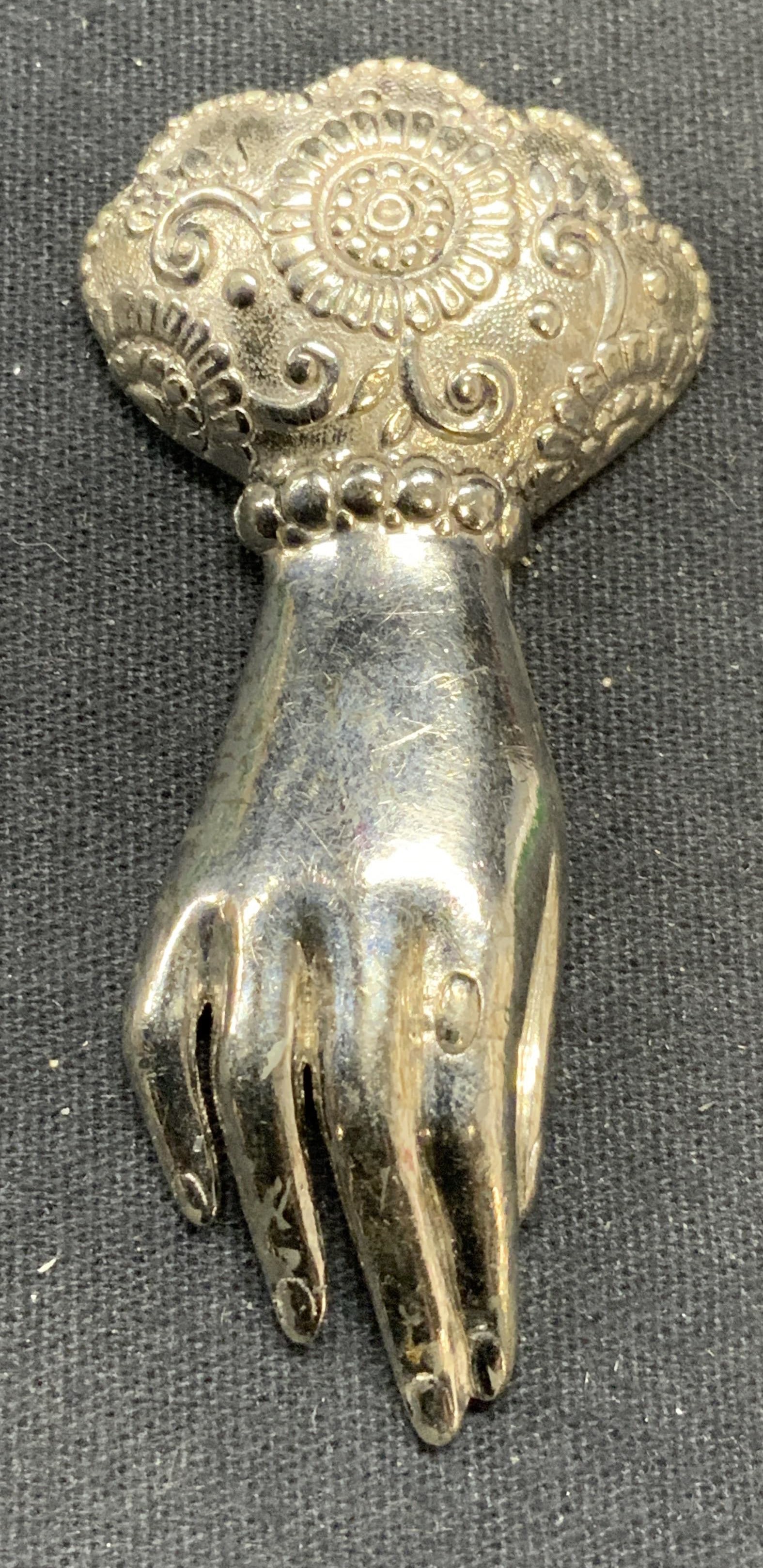 TRIFARI Silver Tone Victorian Hand Fur Clip 2.5in: Vintage Trifari silver tone fur clip with Victorian style hand motif. Signed to underside. Measures approx. 2.5 x 1.25 inches. Some surface wear including scratching observed. Includes jewelry box. Es