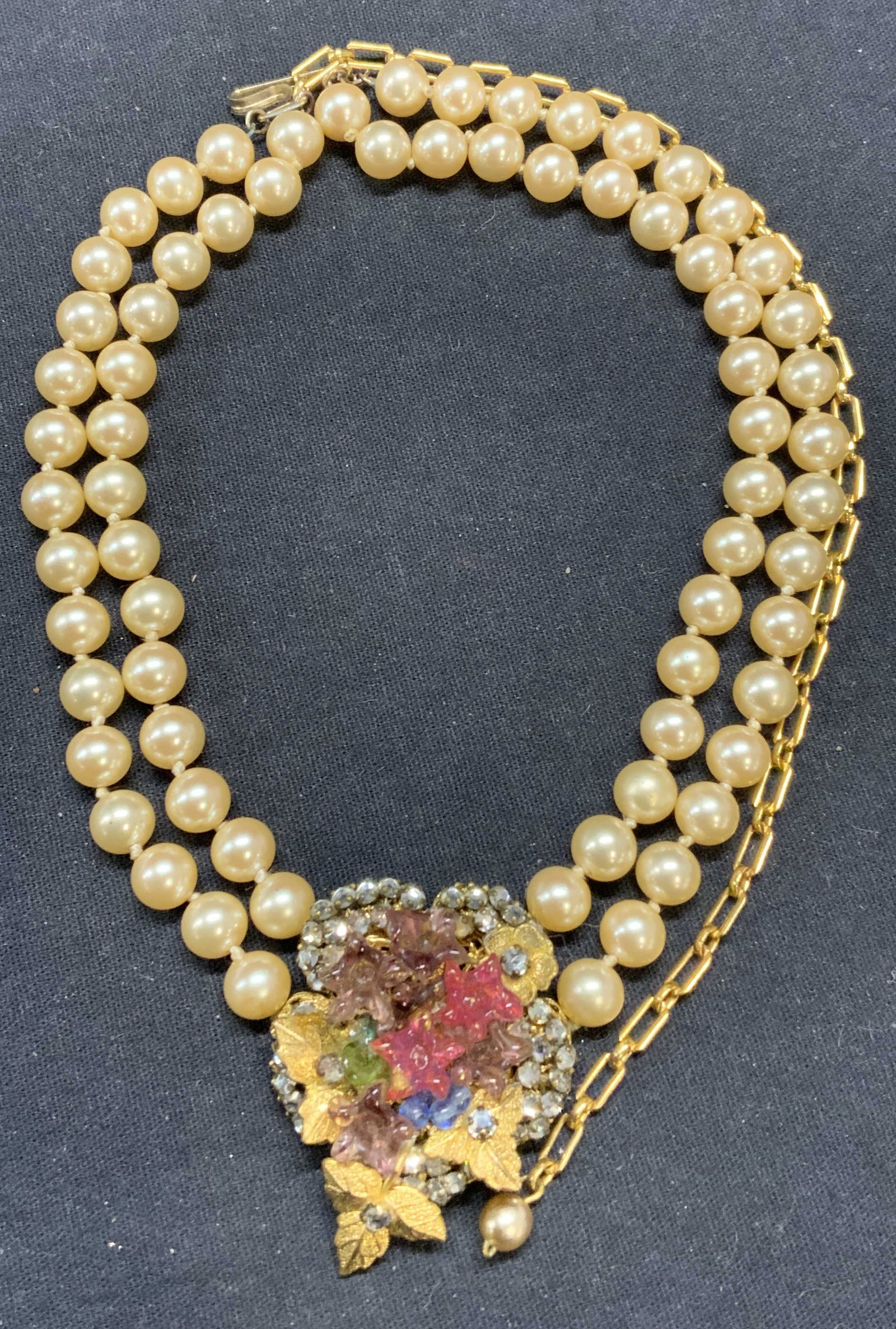Faux Pearl Floral Crystal Pendant Necklace: Vintage gold tone faux pearl double strand necklace with floral crystal, decorated pendant. Drop length approx. 11 inches. Pendant measures approx. 1.5 x 1.75 inches. Some surface wear including scrat