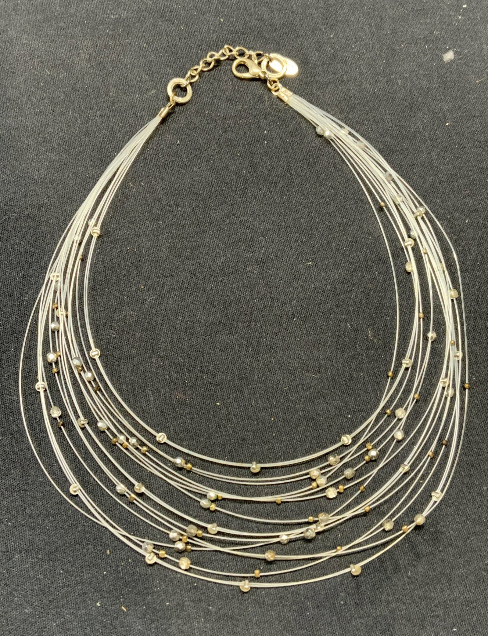SEASONAL WHISPERS Crystal Wire Necklace: Seasonal Whispers transparent wire multi strand necklace with crystal beads. Signed on hangtag. Drop length approx. 6 inches. Some surface wear consistent with exposure. Estate jewelry, costume jewelr