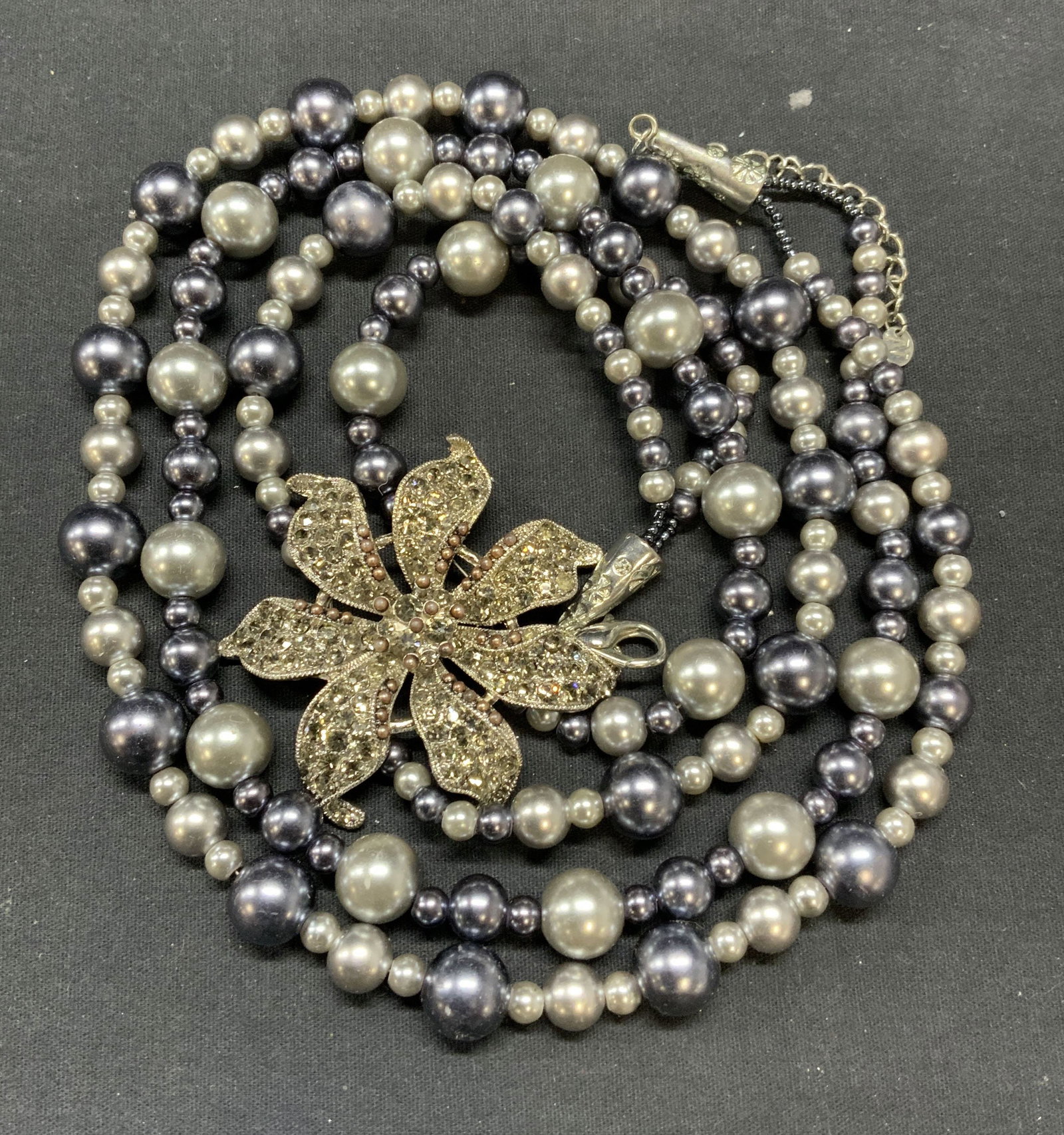 NENA Faux Pearl Crystal Flower Pendant Necklace: Vintage NENA faux Tahitian pearl double strand necklace with silver tone crystal decorated flower pendant. Signed on hang tag. Drop length of shortest strand approx. 16 inches. Pendant measures approx
