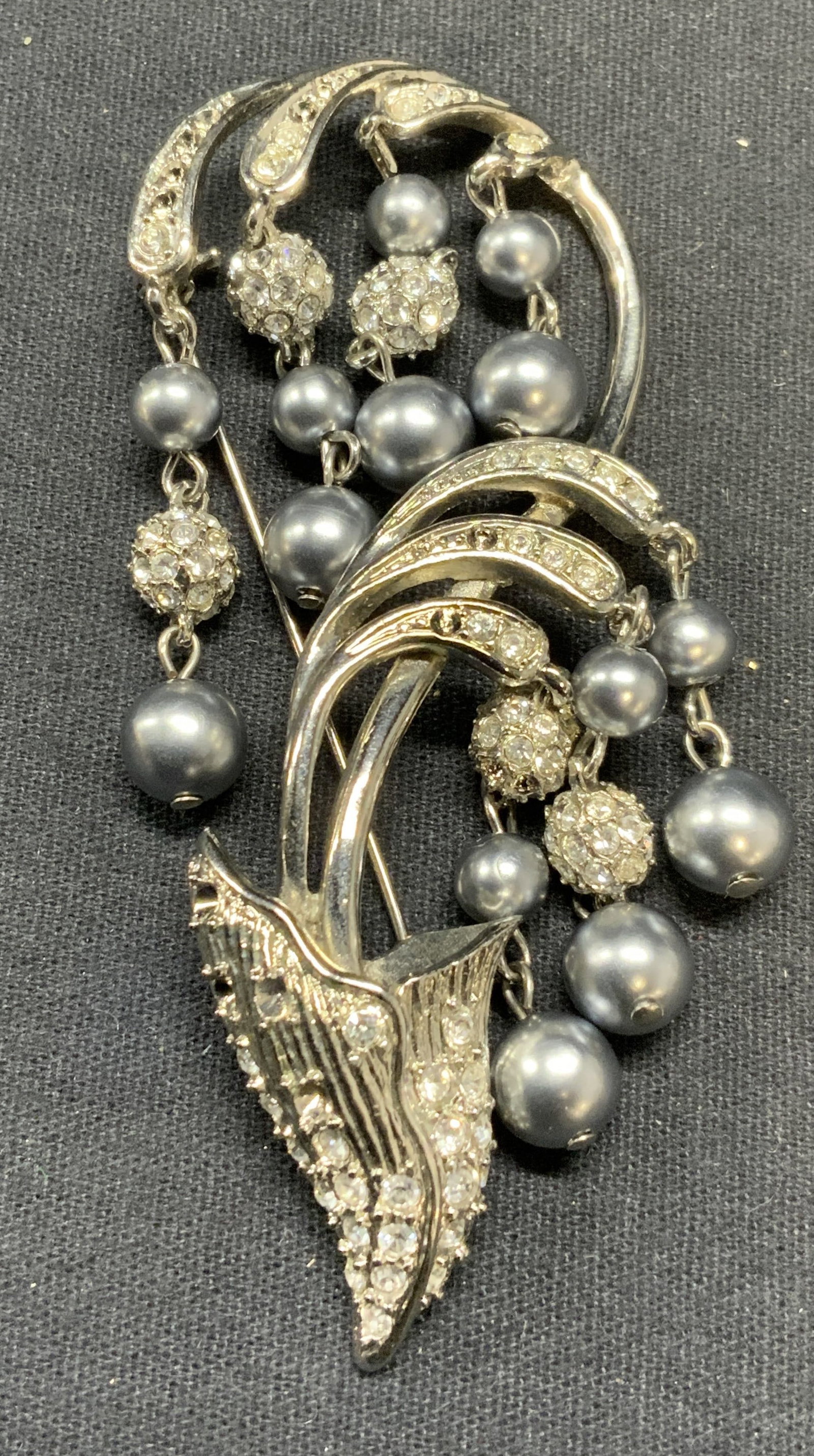 Silver Tn Faux Pearl Crystal Flower Brooch 3.25in: Vintage silver tone crystal and faux Tahitian pearl decorated flower brooch. Hinge pin to underside. Measures approx. 3.25 x 1.5 inches. Some scratching observed. Some crystals need replacement. Estat